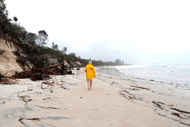 <p>A man walking along a stretch of coast in Byron Bay</p>