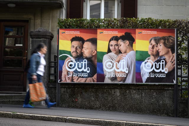 <p>A woman walks past an electoral poster in the town of Lausanne, Switzerland ahead of a nationwide vote on  same-sex marriage  </p>