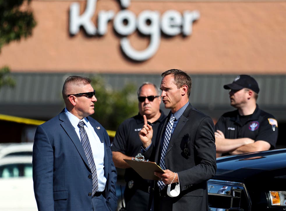 <p>Law enforcement officers confer at the scene following the shooting</p>