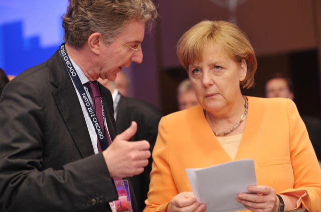 <p>German Chancellor Angela Merkel  chats with Christoph Heusgen at a Nato summit </p>