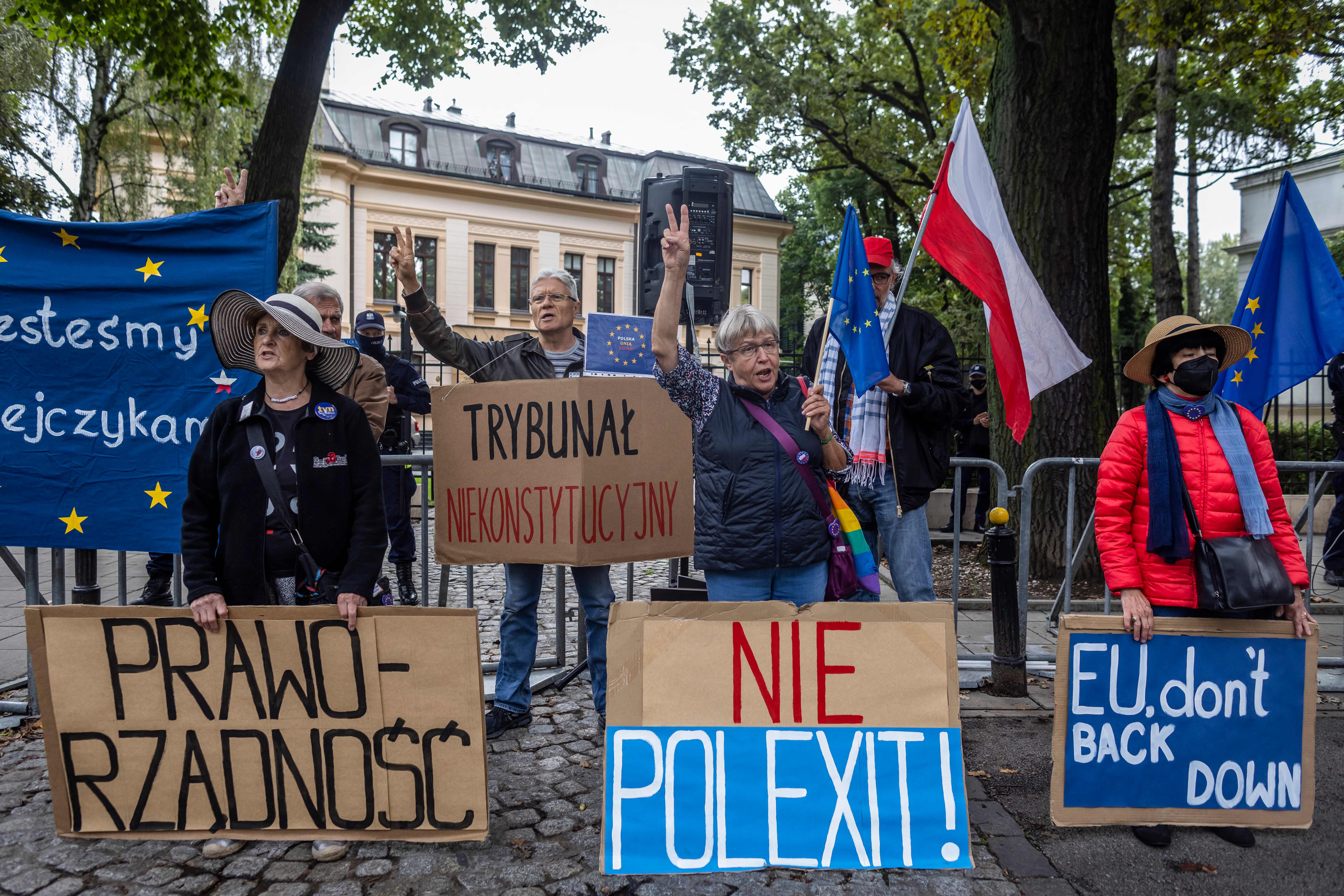 Demonstrators hold banners reading (from L) “Rule of Law”, “Unconstitutional Court”, “No to Polexit” and “EU don’t Back Down” as they take part in a protest in August