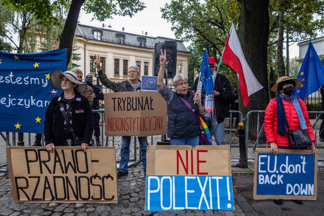 <p>Demonstrators hold banners reading (from L) “Rule of Law”, “Unconstitutional Court”, “No to Polexit” and “EU don’t Back Down” as they take part in a protest in August </p>