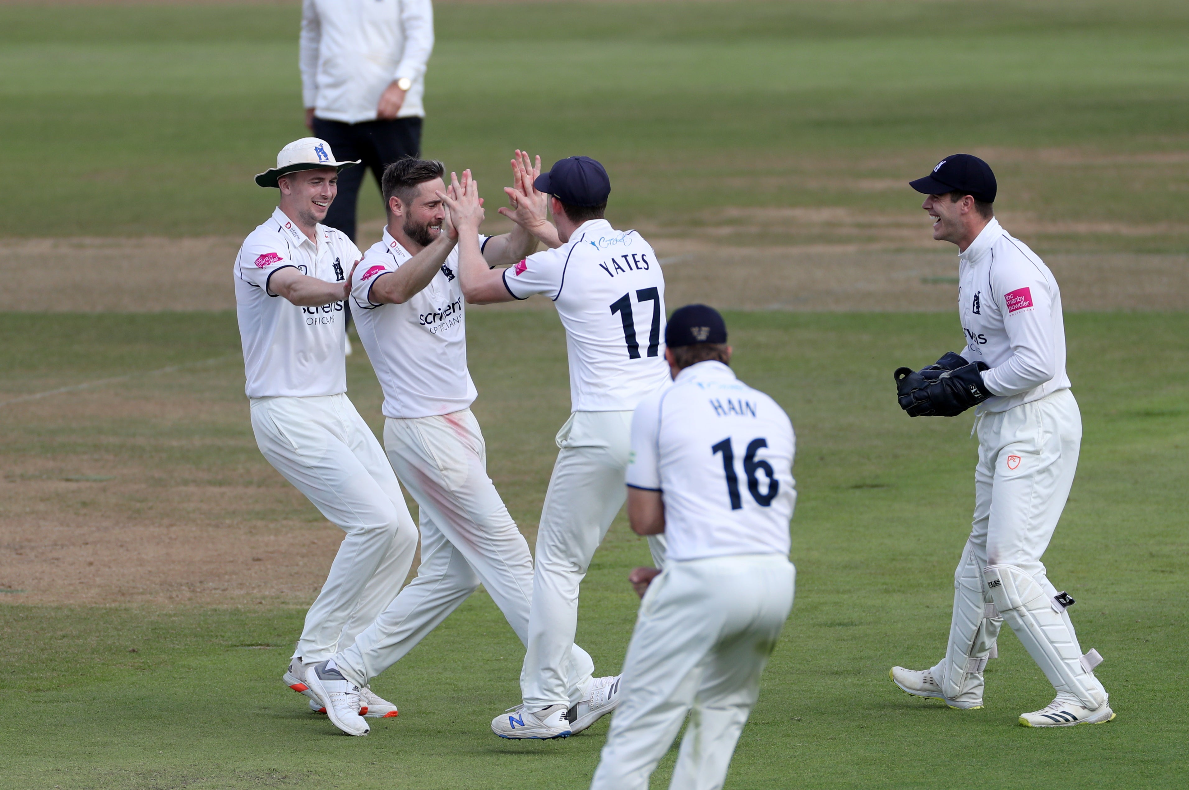 Chris Woakes is congratulated by team-mates for dismissing Warwickshire’s Jack Leach