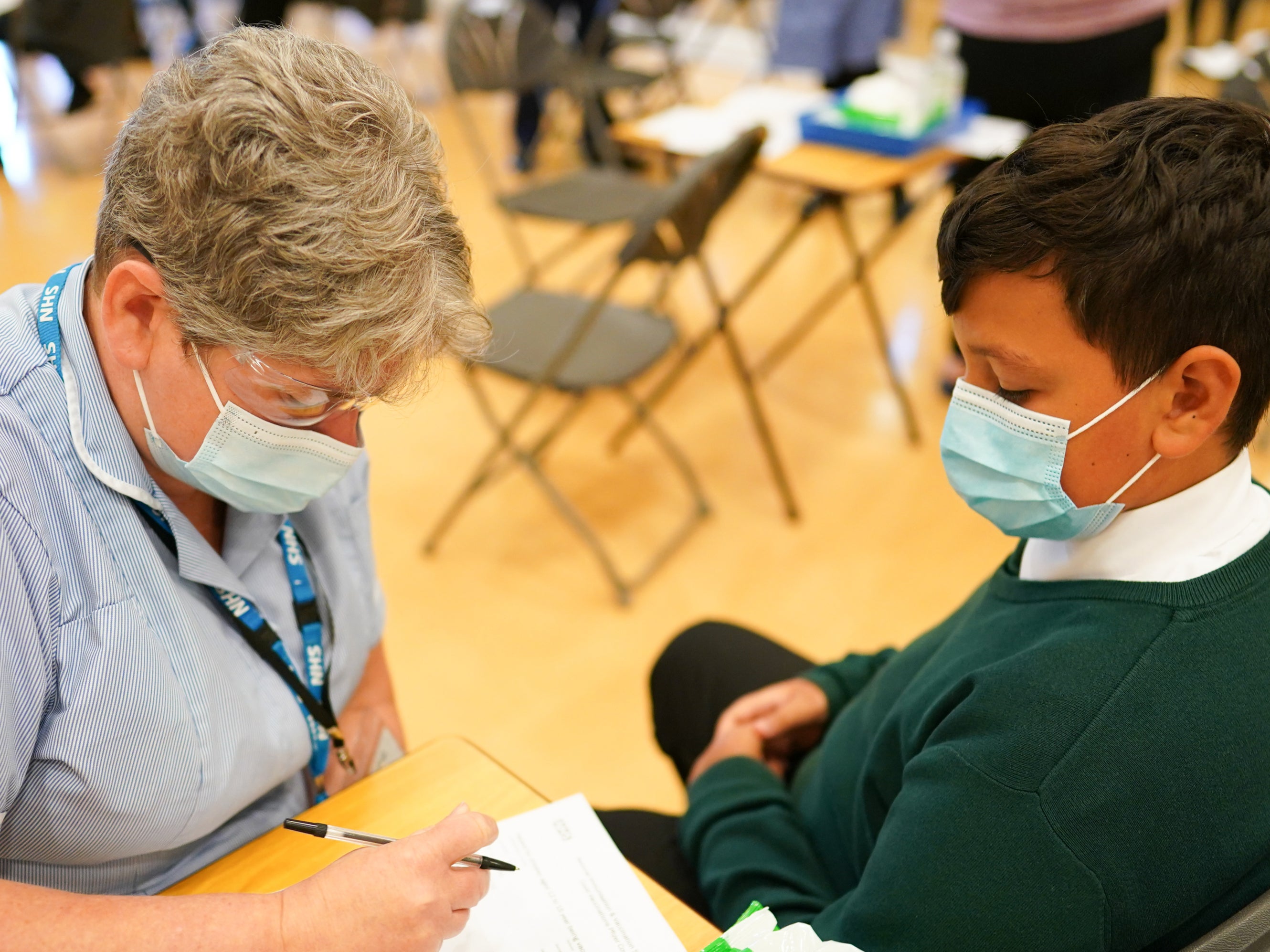 A 13-year-old from Newcastle speaks with a nurse on Wednesday before he receives the Pfizer Covid vaccine