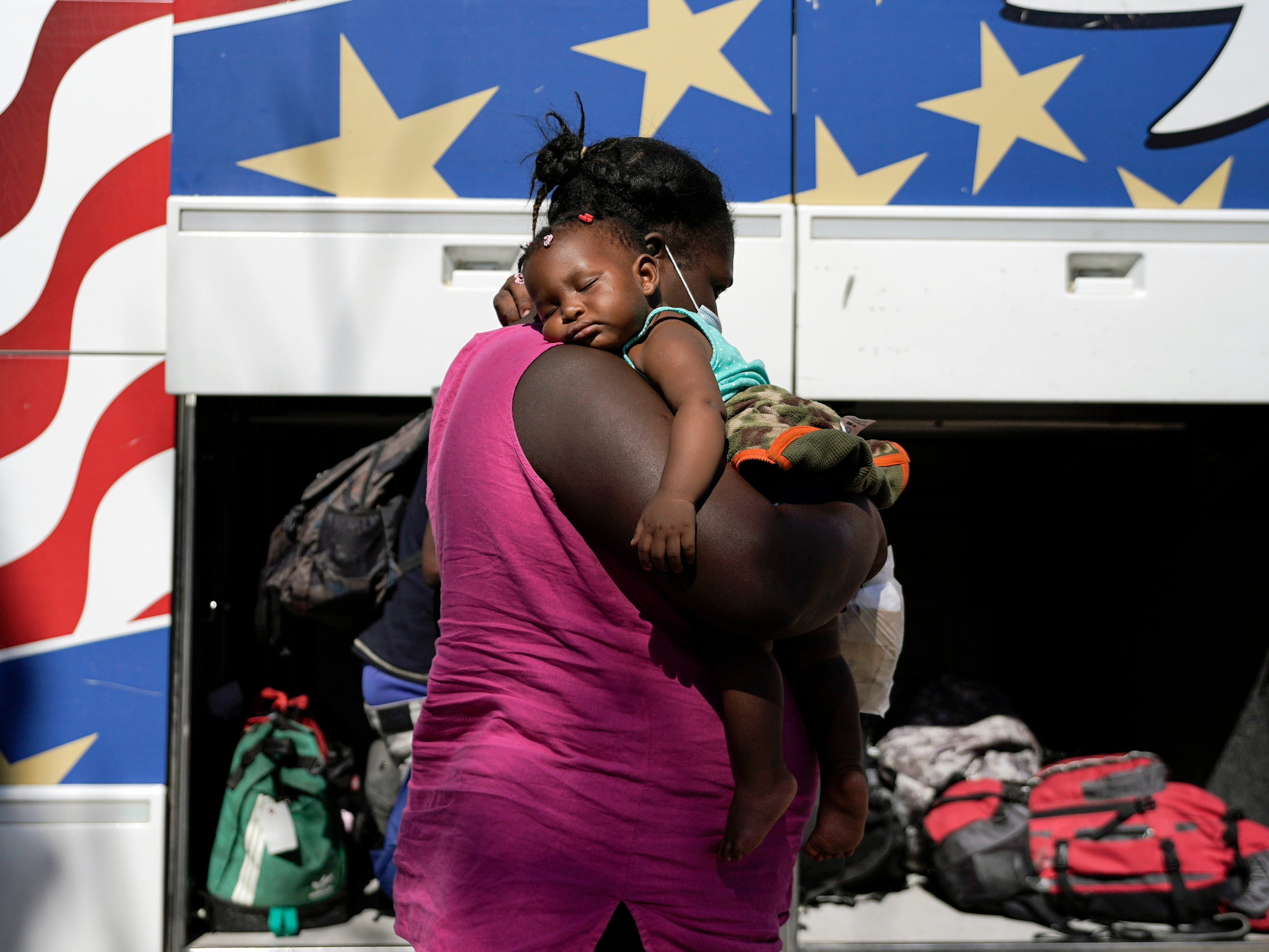 Una madre y su hijo se preparan para abordar un autobús lejos de la frontera entre Estados Unidos y México.