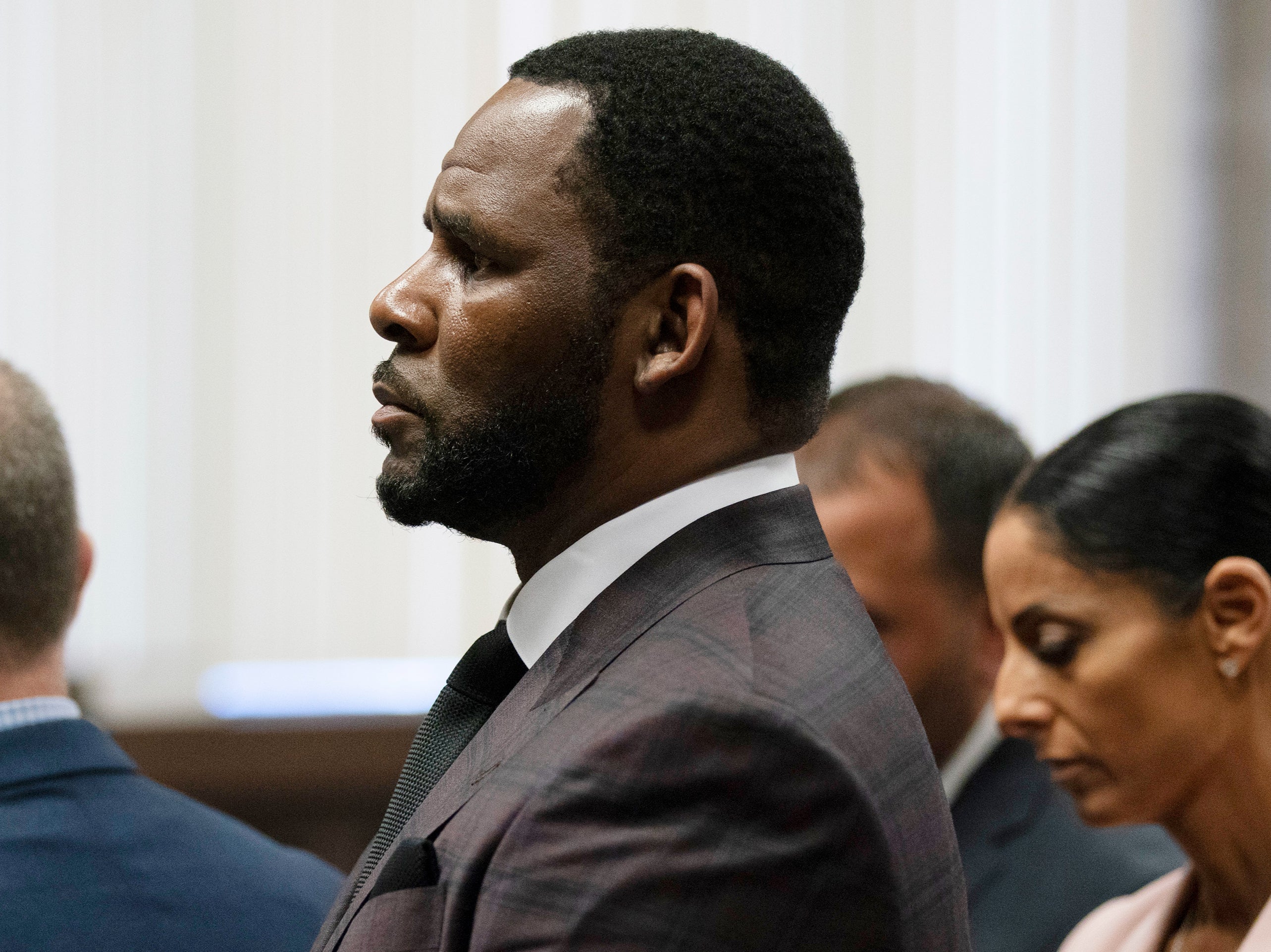 R Kelly (centre) appears at a court hearing on 26 June 2019 in Chicago, Illinois