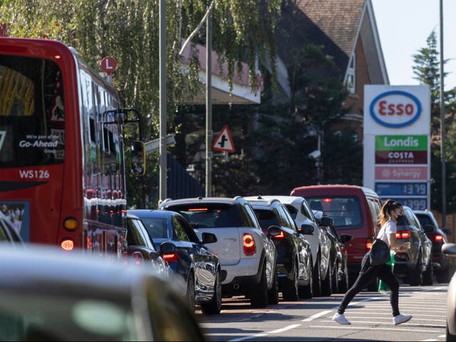 <p>A queue forms for an Esso petrol station in London</p>