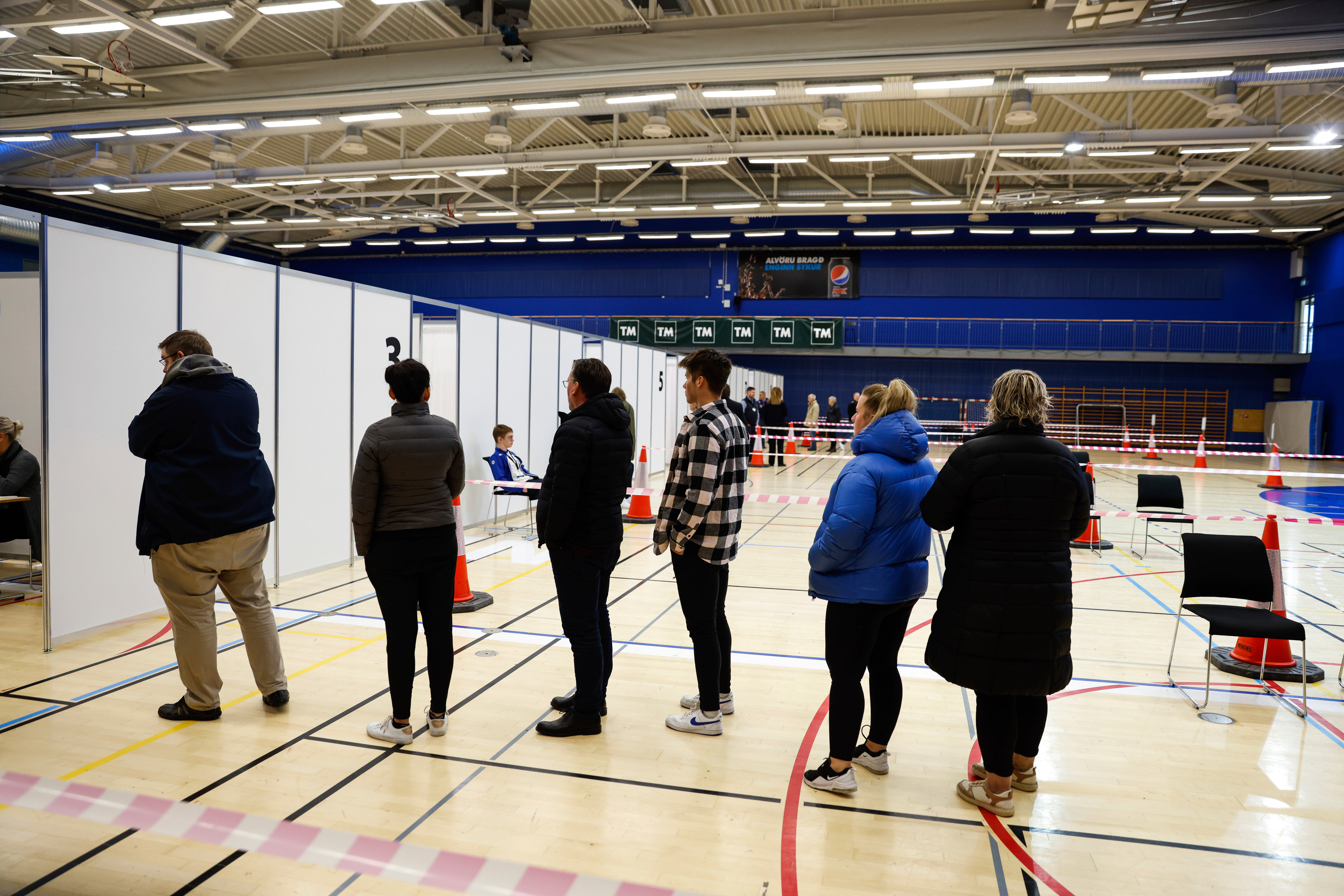 People line up to vote at a polling station in Gardabae, Iceland