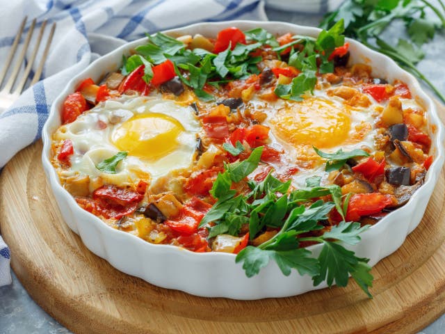 <p>Meltingly soft: spiced aubergine and tomatoes with runny eggs</p>