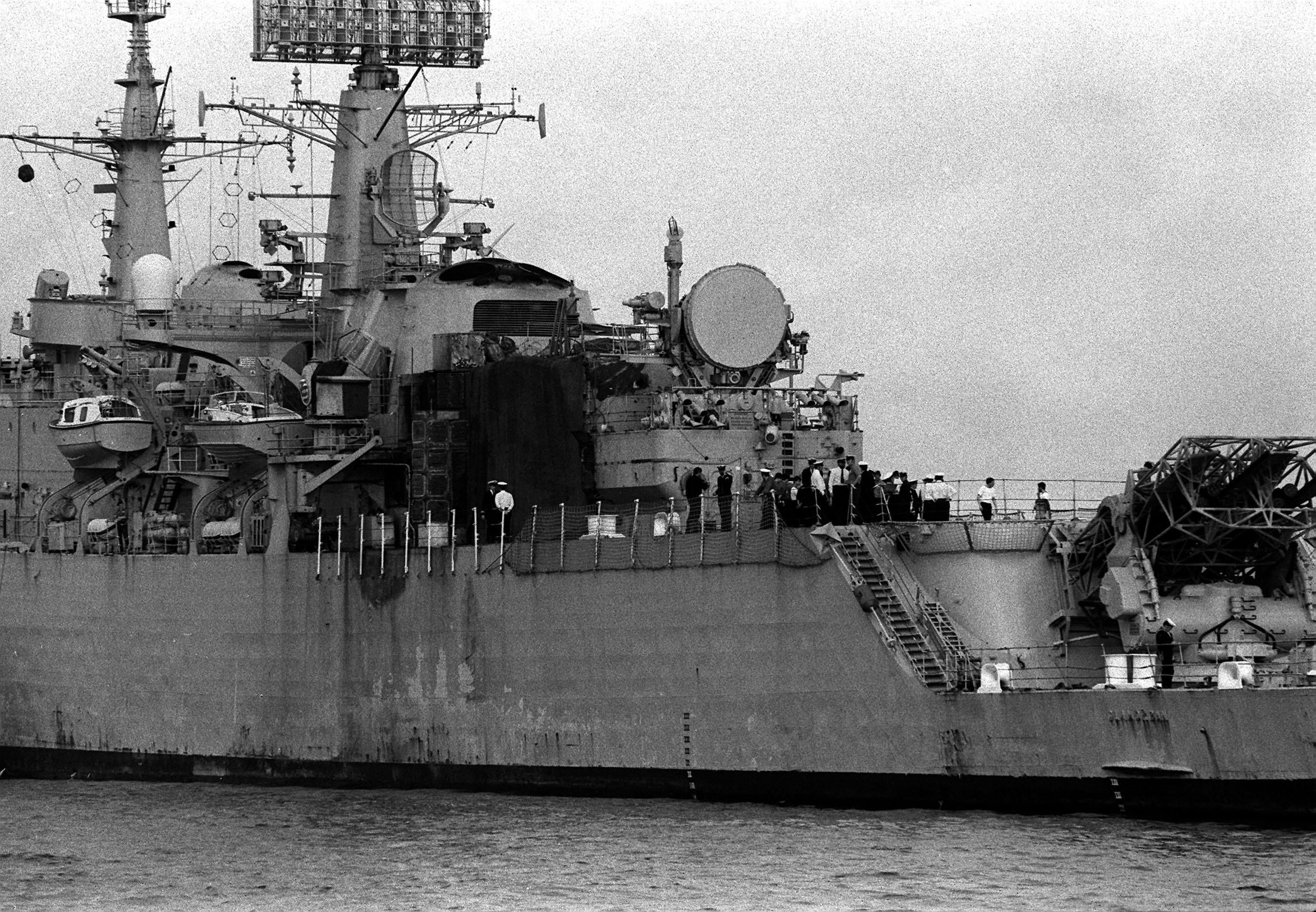 HMS Glamorgan streams into Portsmouth harbour, a tarpaulin covering the spot where it was hit by a shore-launched Exocet missile during the Falklands conflict