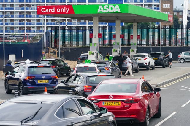 <p>Cars queue for fuel at an Asda petrol station in south London</p>