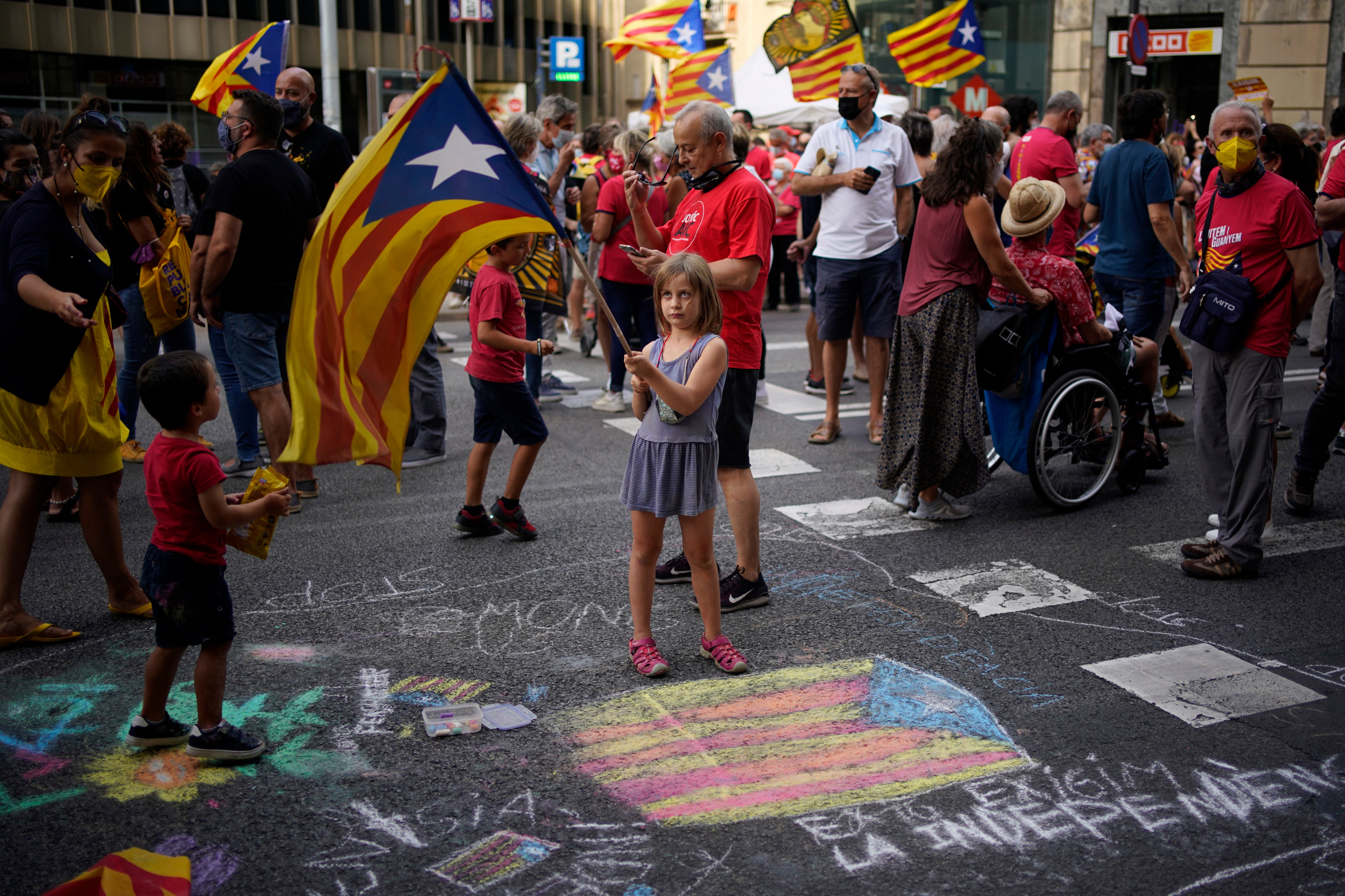 A girl waves a pro-independence flag as demonstrators march during the Catalan National Day in Barcelona earlier in September