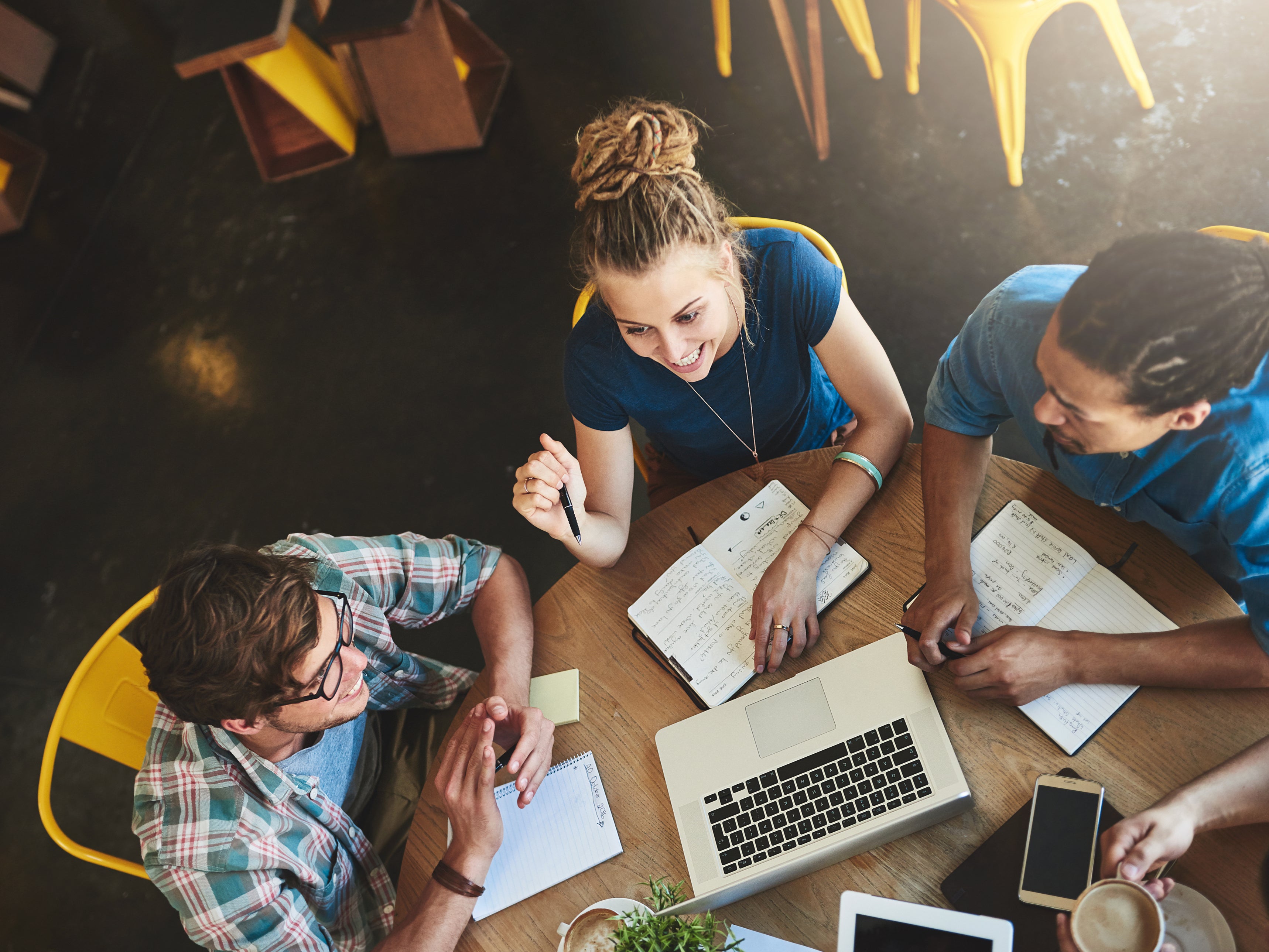 <p>High angle shot of a group of students studying in a coffee shop</p>