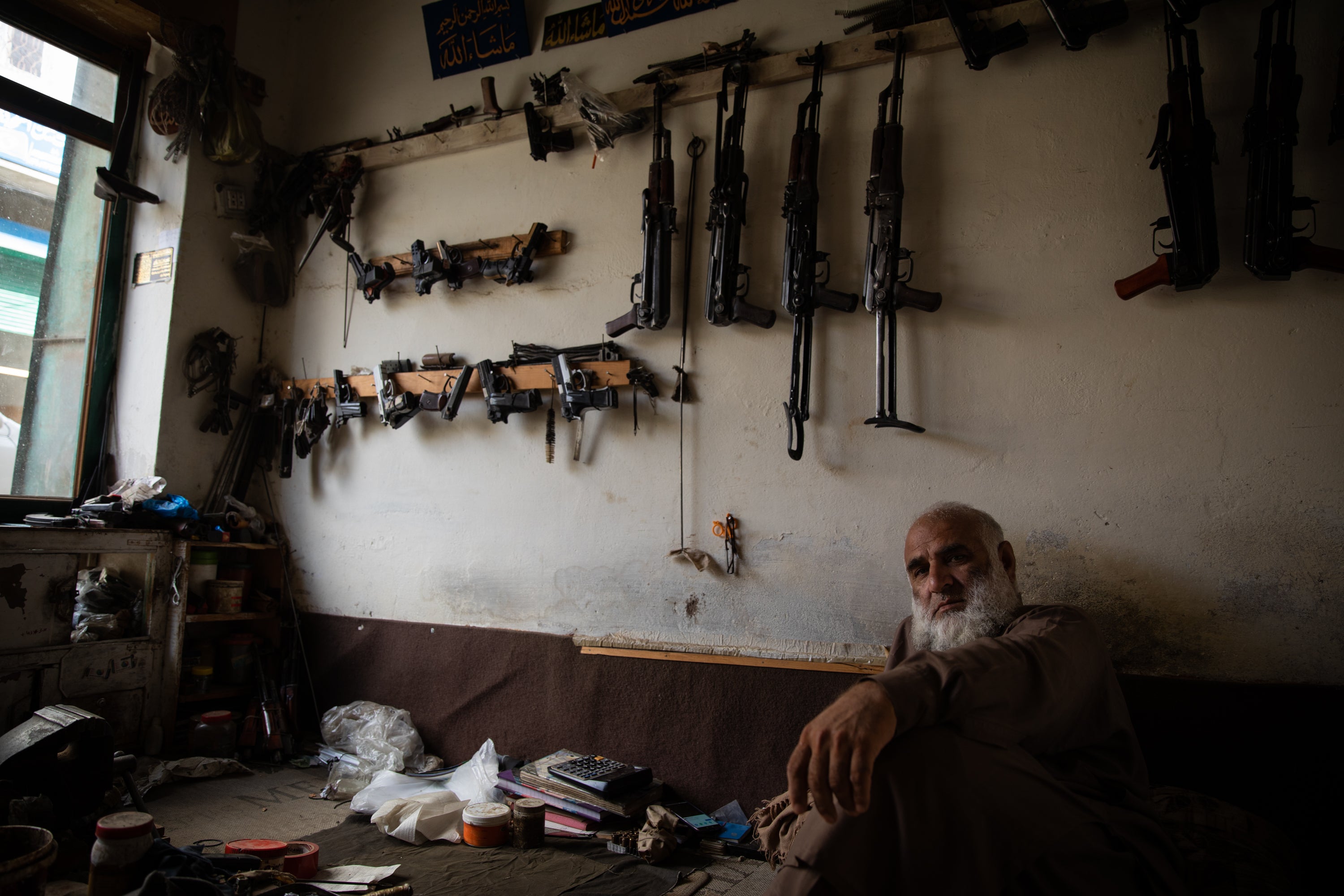 A 50-year-old man sits in his weapon shop near Peshawar, Pakistan.