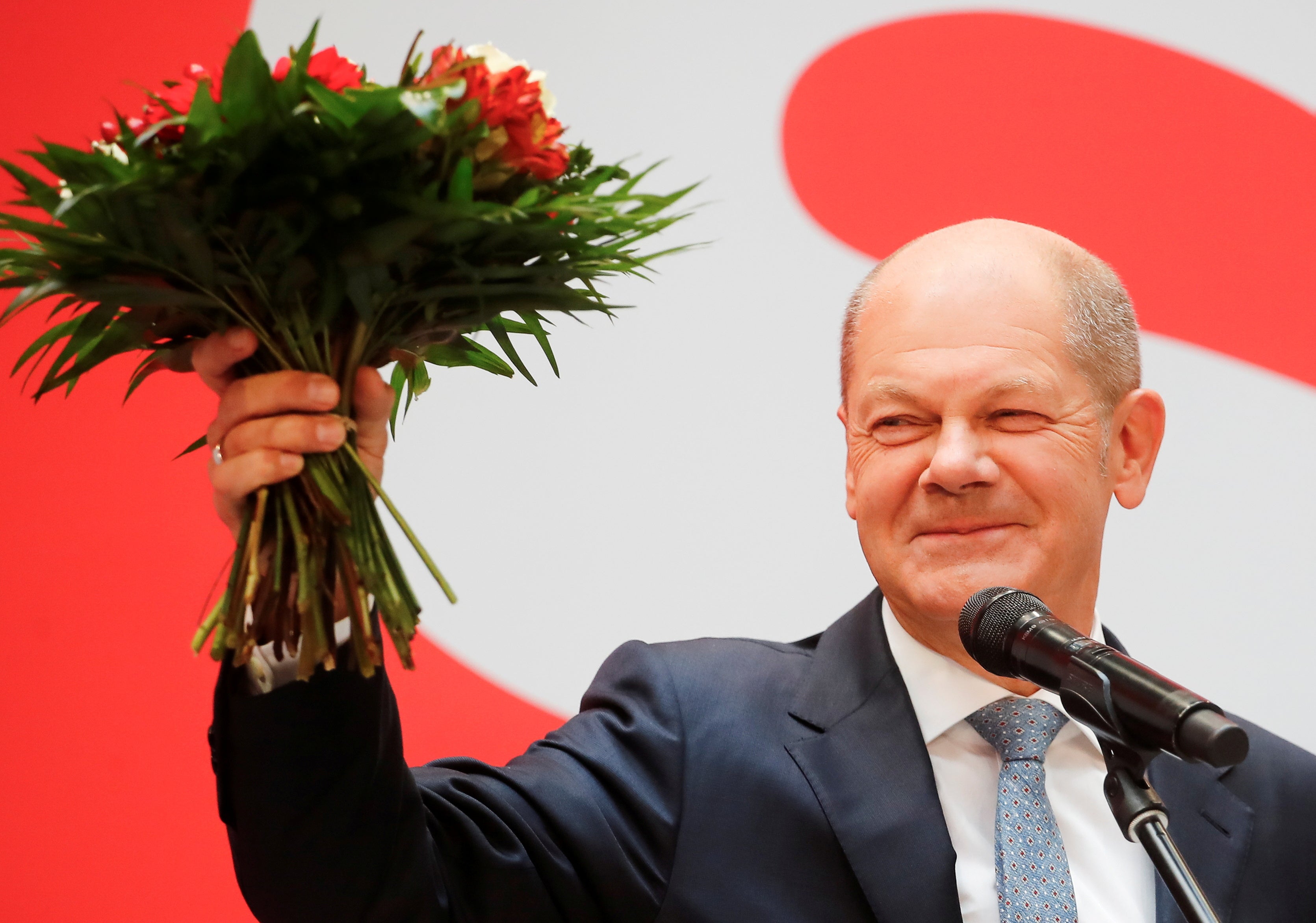 Olaf Scholz holds a bouquet of flowers at their party leadership meeting, a day after the election