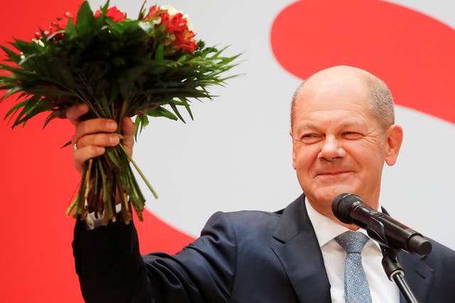 <p>Olaf Scholz holds a bouquet of flowers at their party leadership meeting, a day after the election </p>