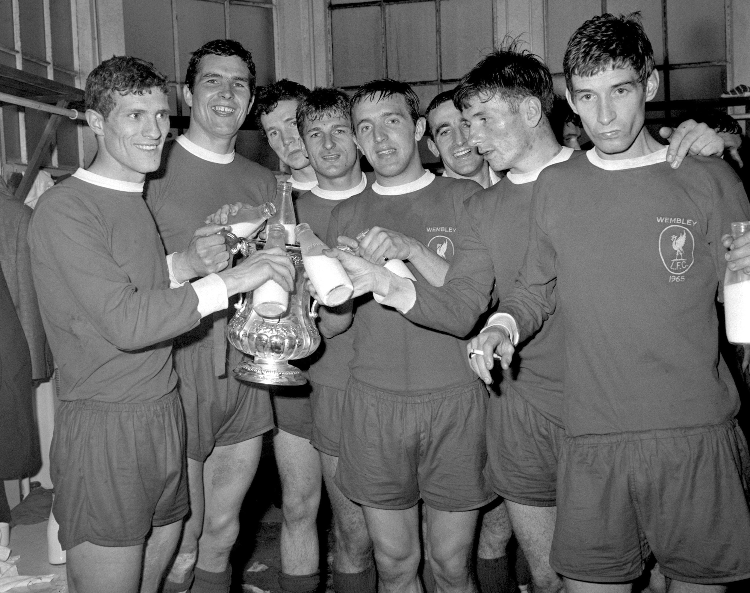 Hunt, fourth from left, and his Liverpool team-mates celebrate winning the 1965 FA Cup with a bottle of milk each (PA Archive)