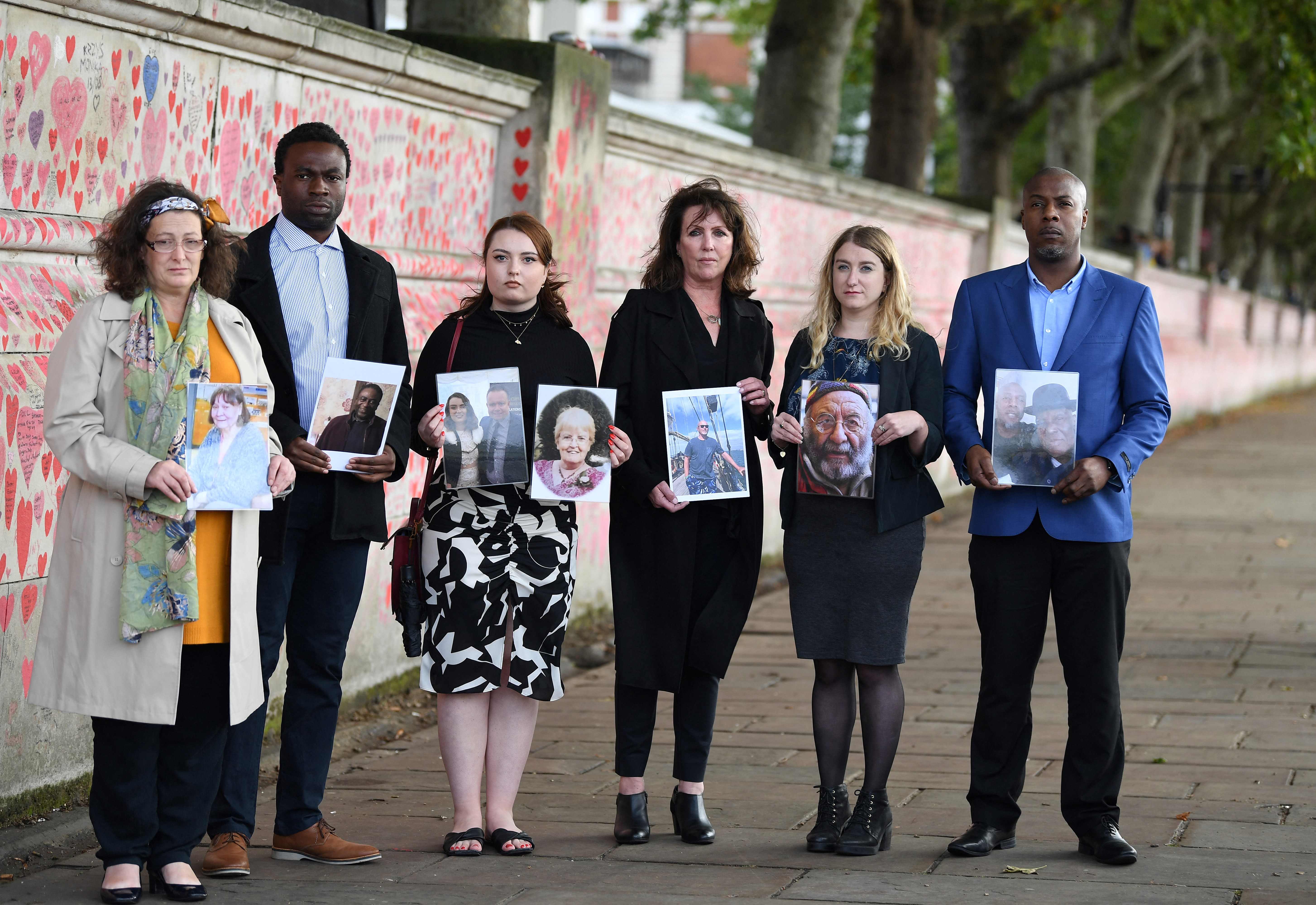 Members of the Covid-19 Bereaved Families for Justice group, from left, Deborah Doyle, Lobby Akinnola, Hannah Brady, Fran Hall, Jo Goodman and Charlie Williams, hold photos of loved ones who died of coronavirus