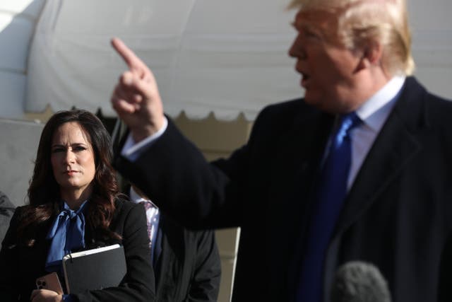 <p>White House press secretary Stephanie Grisham listens to US president Donald Trump talk to reporters in 2019</p>