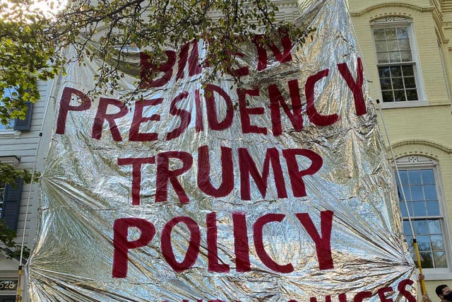 <p>Protesters from Never Again Action hold up a gigantic foil emergency blanket outside the home of Homeland Security secretary Alejandro Mayorkas</p>