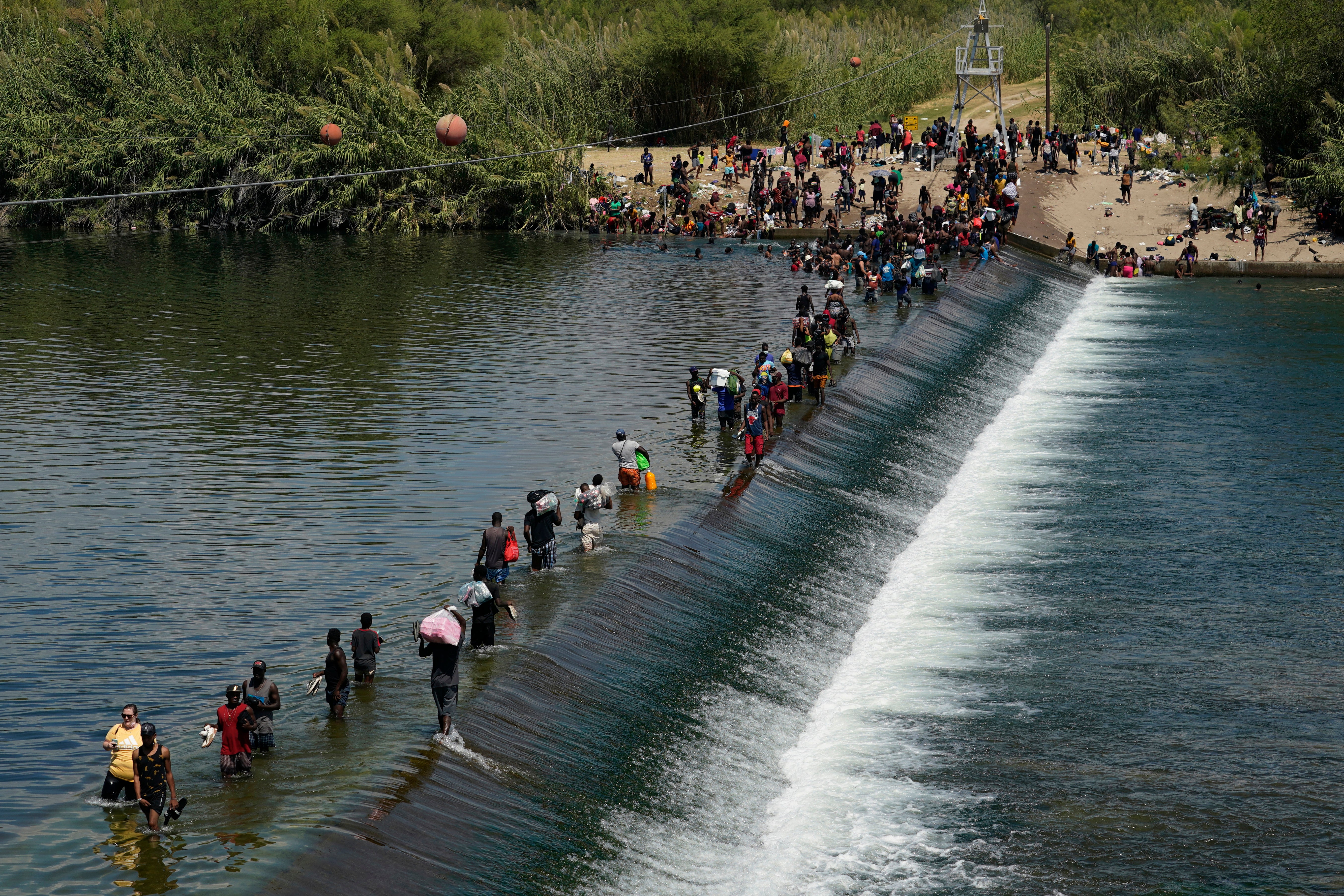 Haitian migrants use a dam to cross from Mexico into the United States
