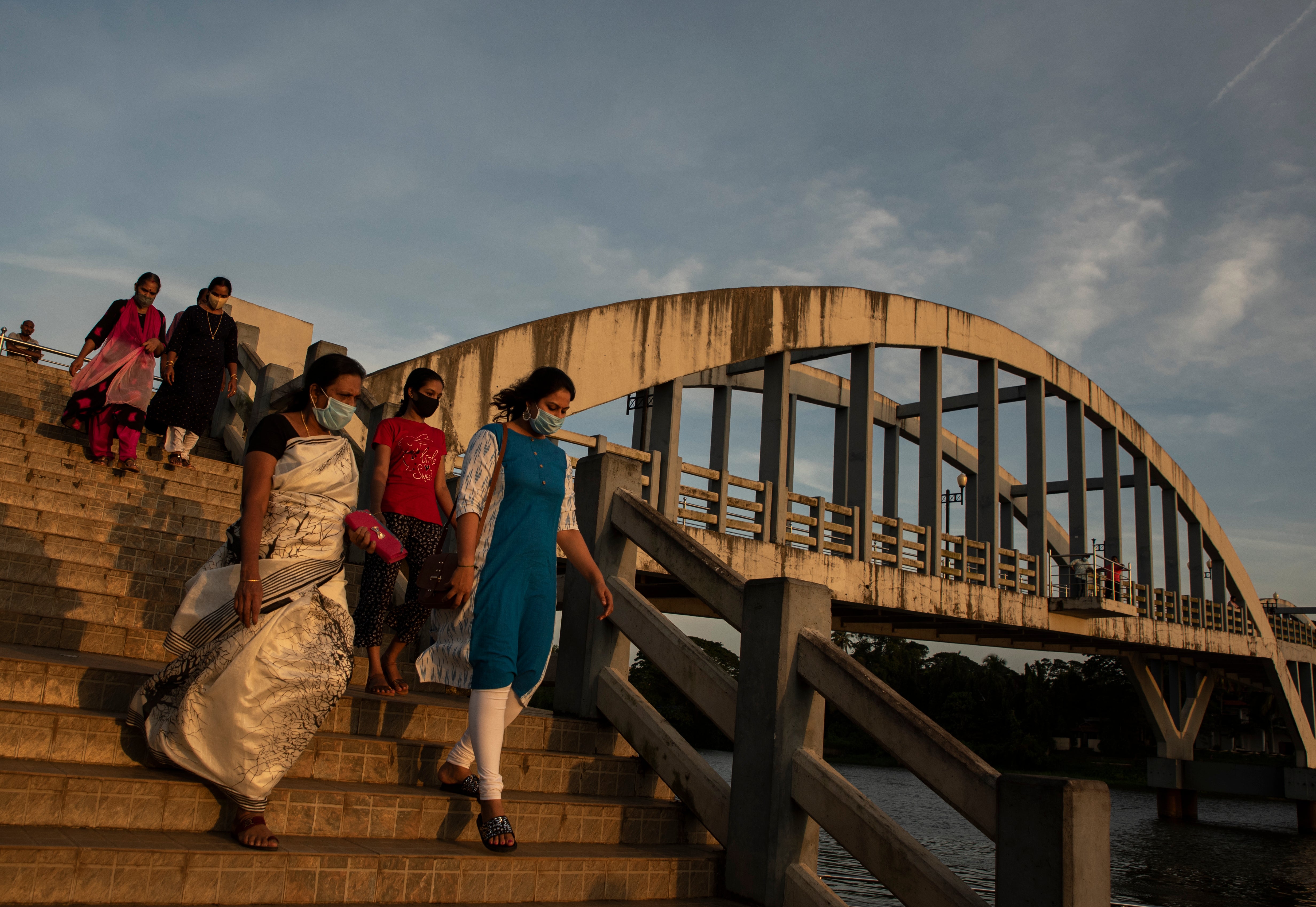 People walk down a pedestrian bridge across River Periyar in Kochi, Kerala state