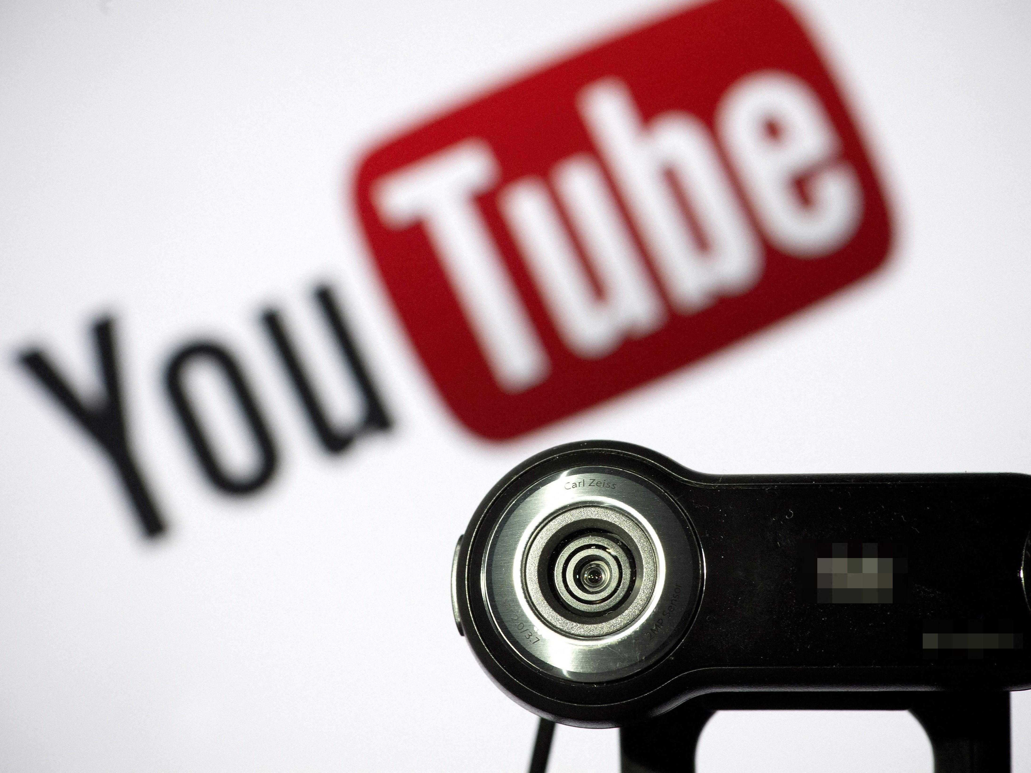A webcam is positioned in front of YouTube’s logo on 28 June, 2013