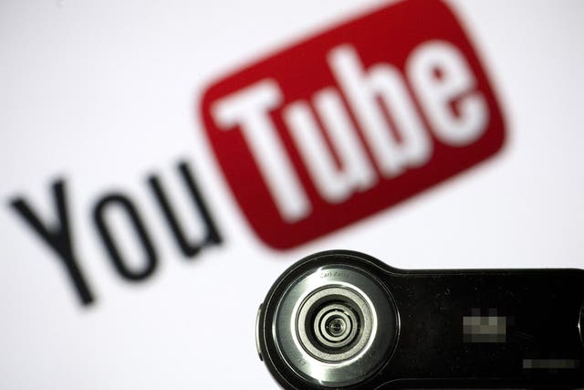 <p>A webcam is positioned in front of YouTube’s logo on 28 June, 2013</p>