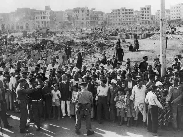 <p>12 November 1956: British soldiers supervise a crowd in Port Said while food is distributed during the Suez Crisis</p>