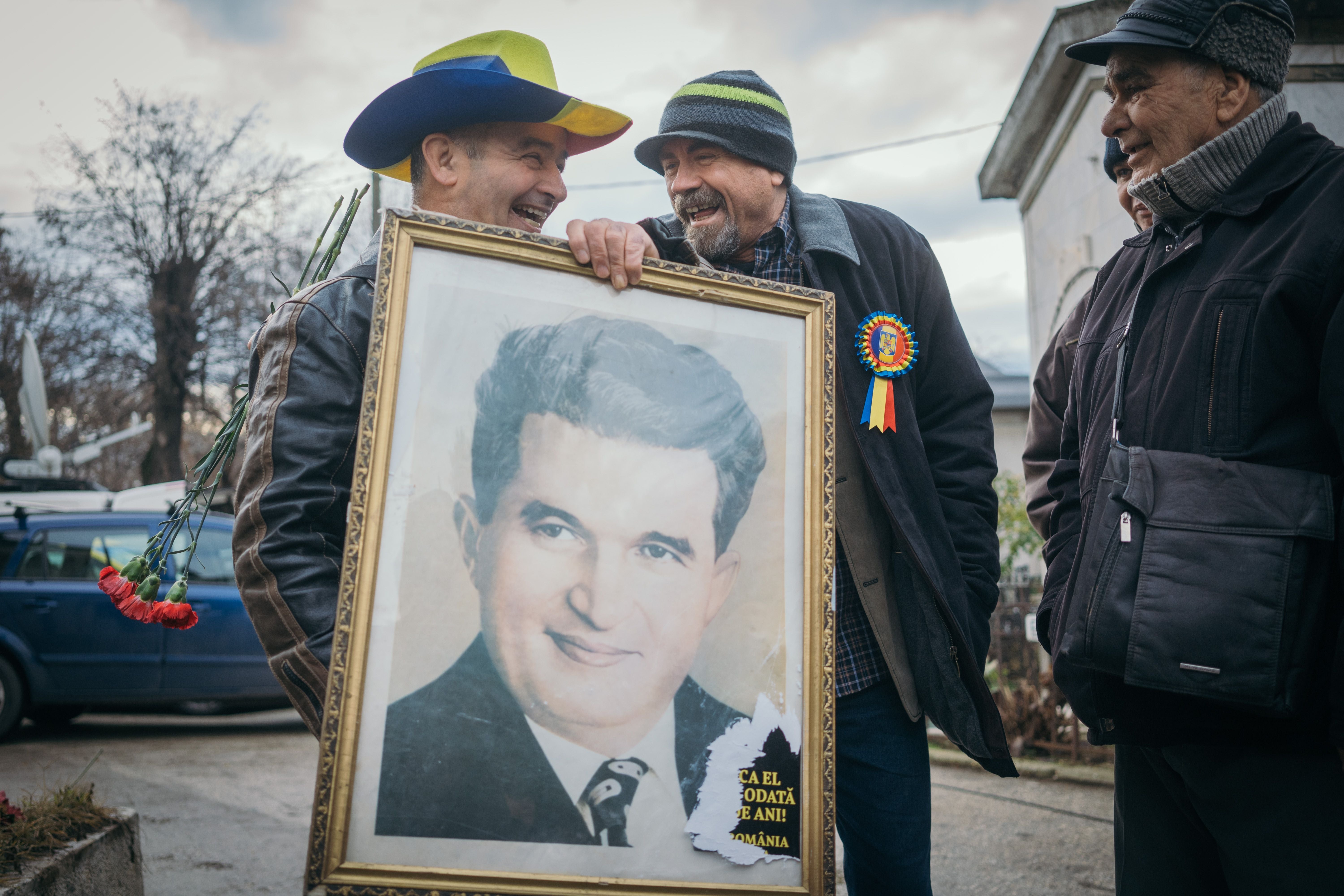 Romanian communist sympathisers brings a portrait of former dictator Nicolae Ceausescu as they gather on his and his wife Elena’s graves