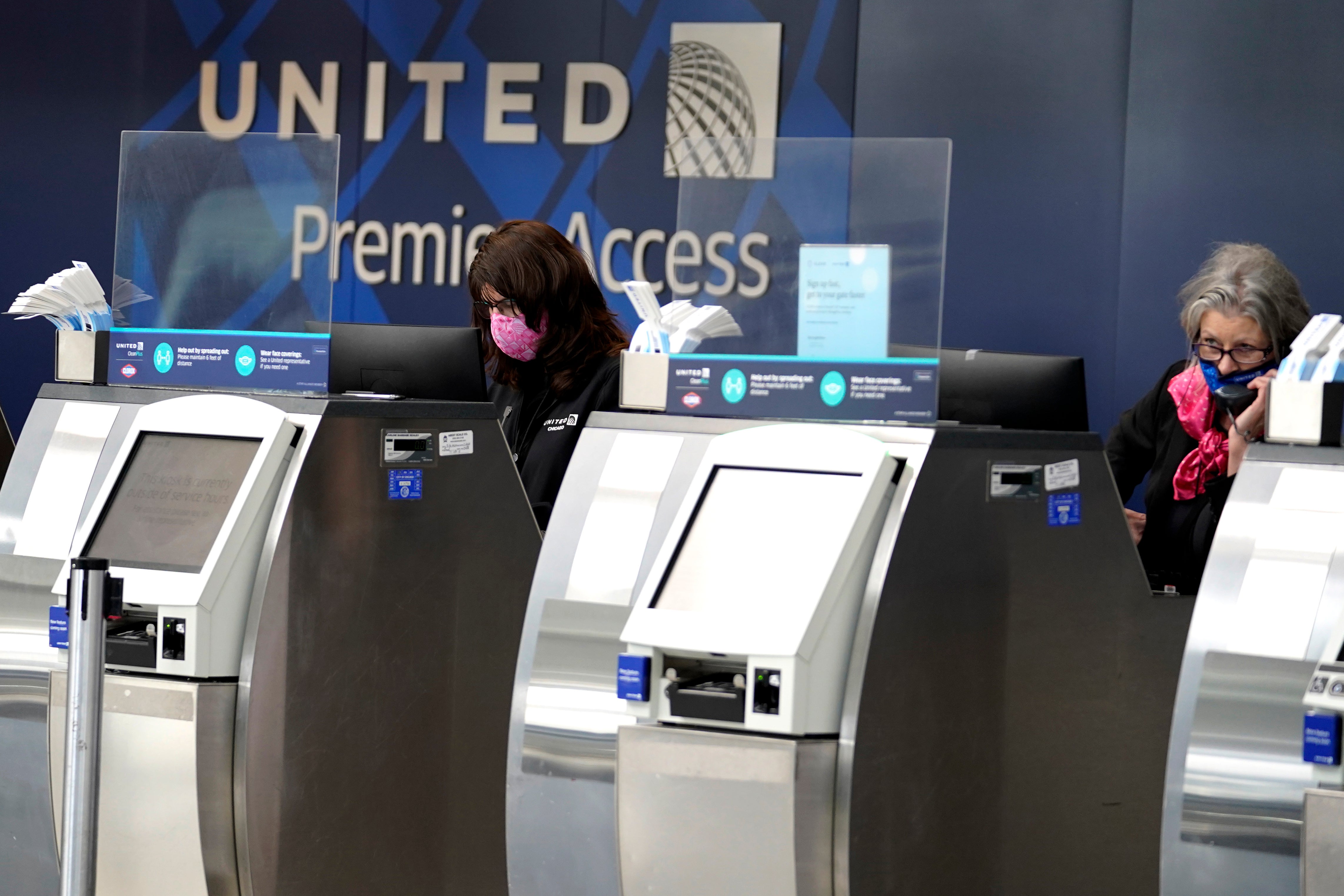 United Airlines employees work at ticket counters in Terminal 1 at O'Hare International Airport in Chicago.