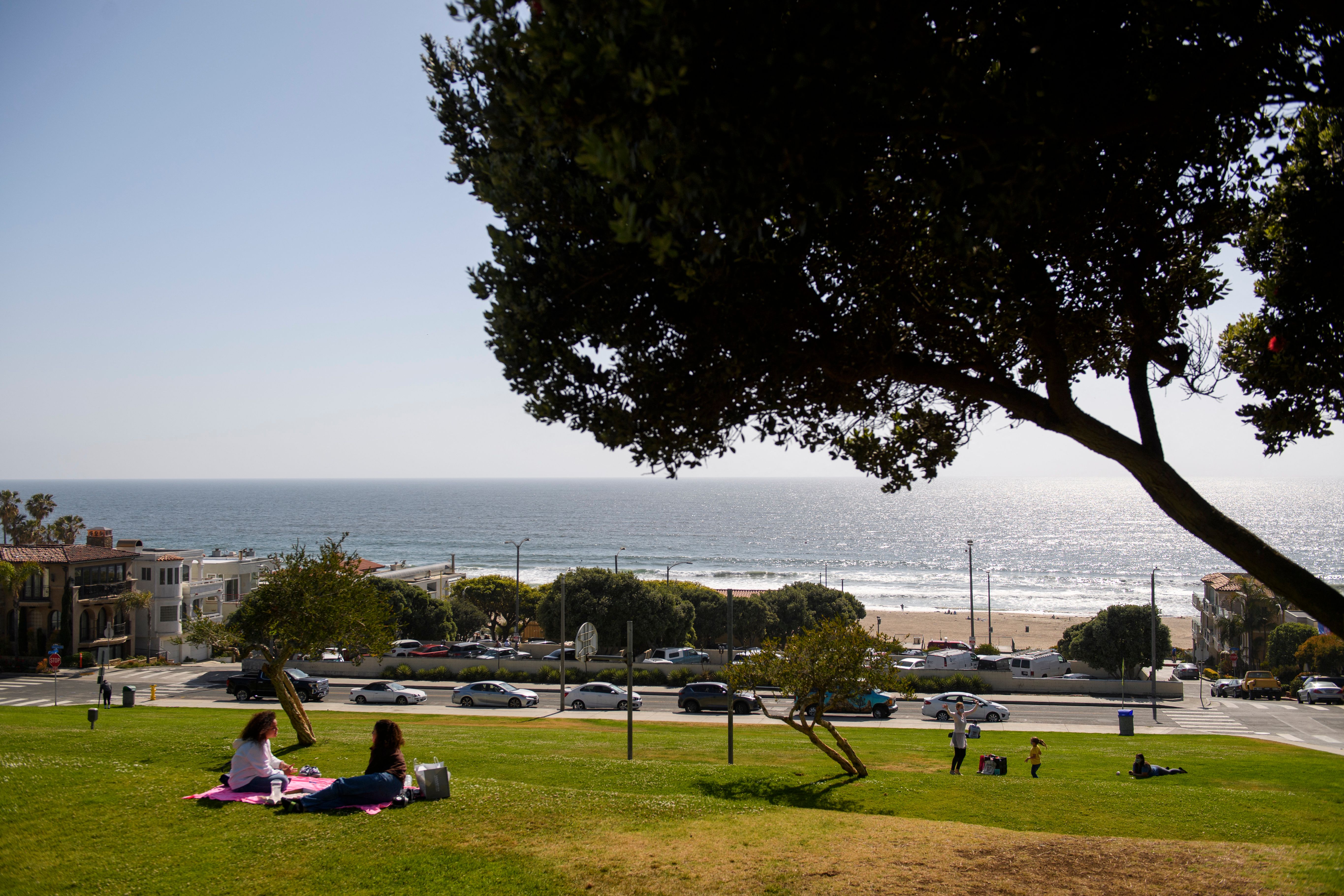People relax at Bruce's Beach park, above a Los Angeles County Fire Department Lifeguard station on April 20, 2021 in Manhattan Beach, California
