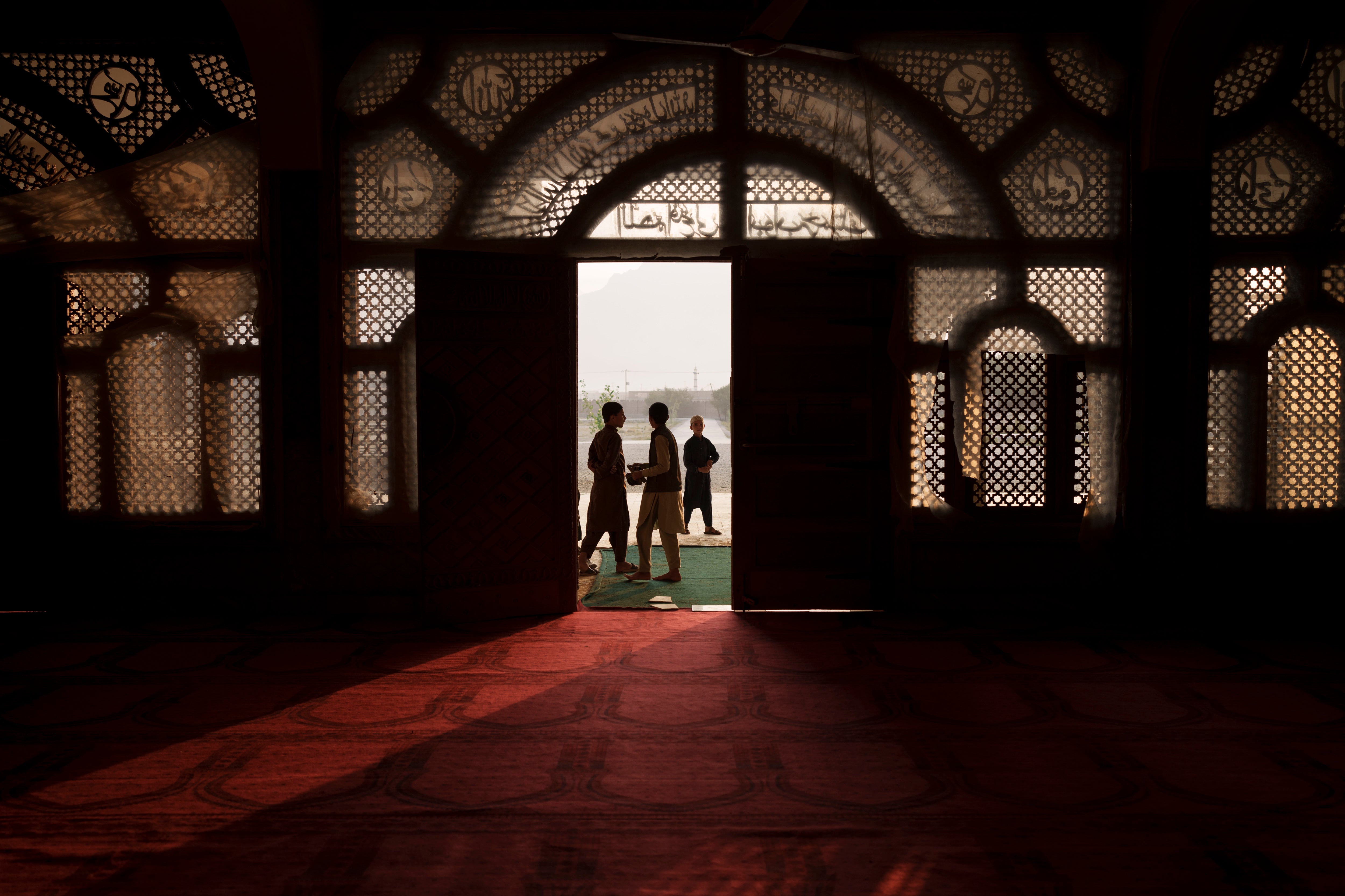 Afghan students walk out of the mosque at the Khatamul Anbiya madrasa after morning prayers in Kabul, Afghanistan