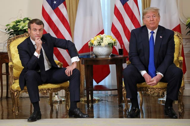 <p>US President Donald Trump (R) and France's President Emmanuel Macron react as they talk during their meeting at Winfield House, London on December 3, 2019</p>