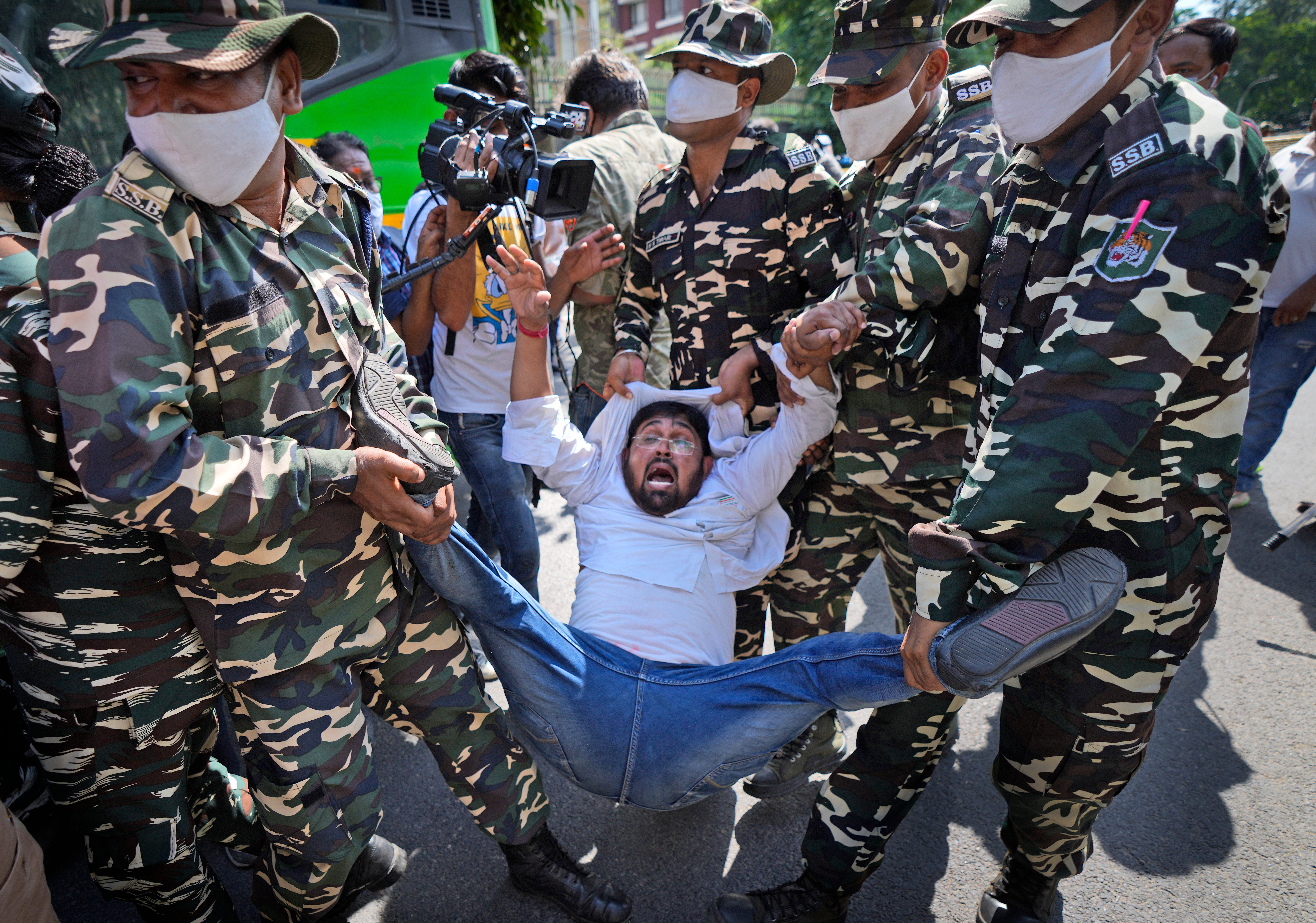 Paramilitary force soldiers detain an activist of Congress party's youth wing protesting against Sunday's killing of four farmers in Uttar Pradesh state after being run over by a car