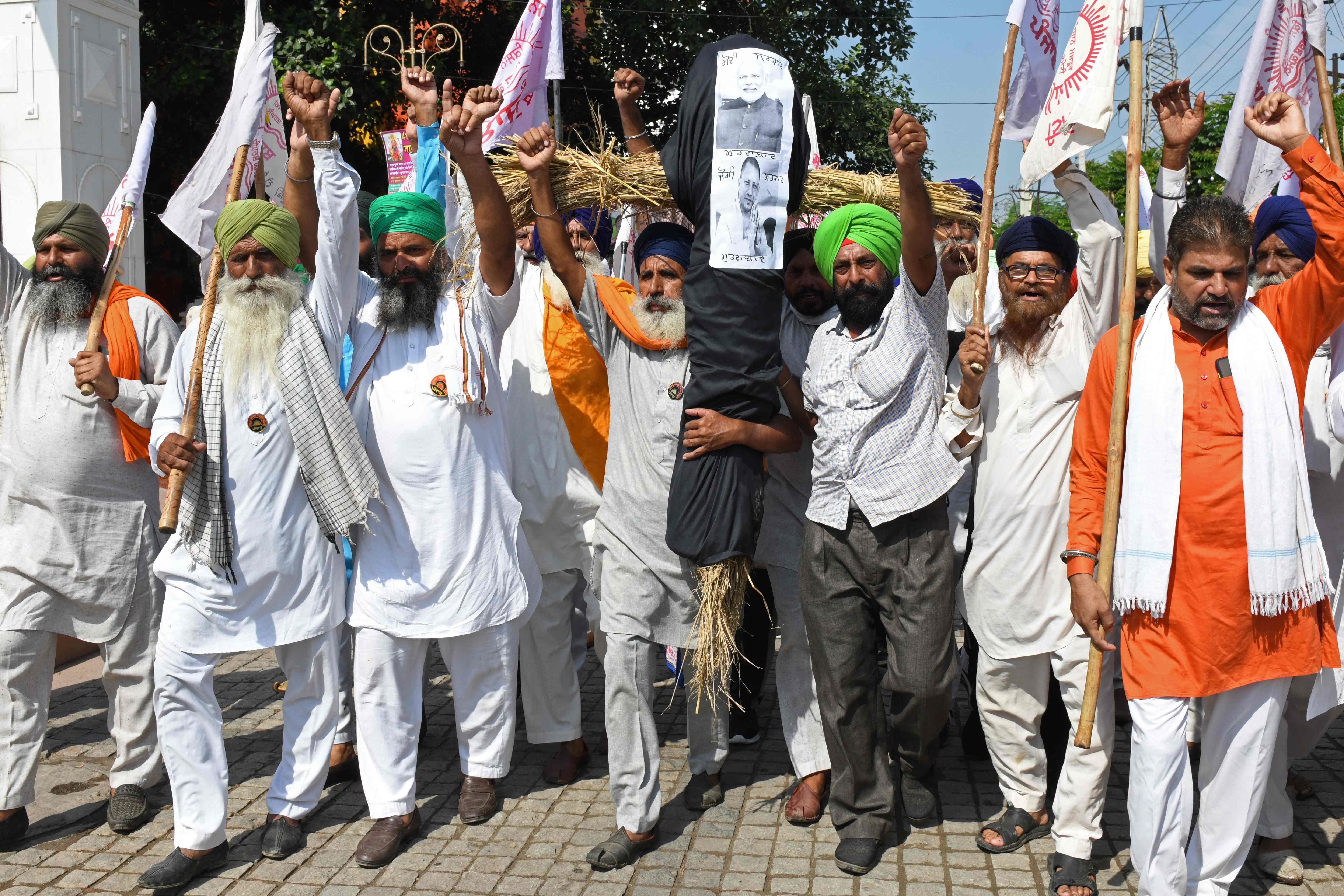 Farmers shout slogans as they carry an effigy of India's prime minister Narendra Modi and Uttar Pradesh state chief Yogi Adityanath during a protest in Amritsar