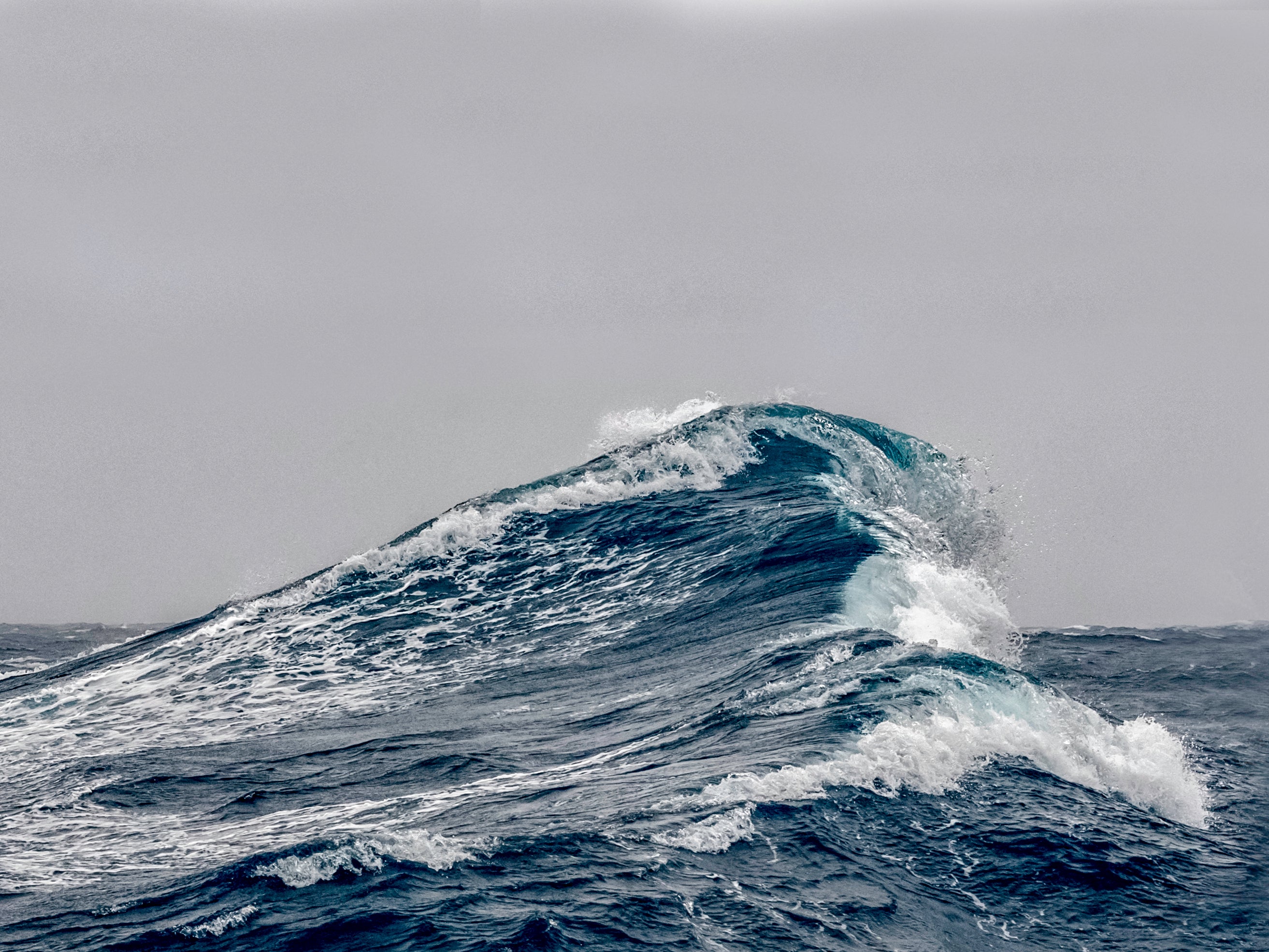 In shallow water, the water on top of a wave travels faster than the water underneath