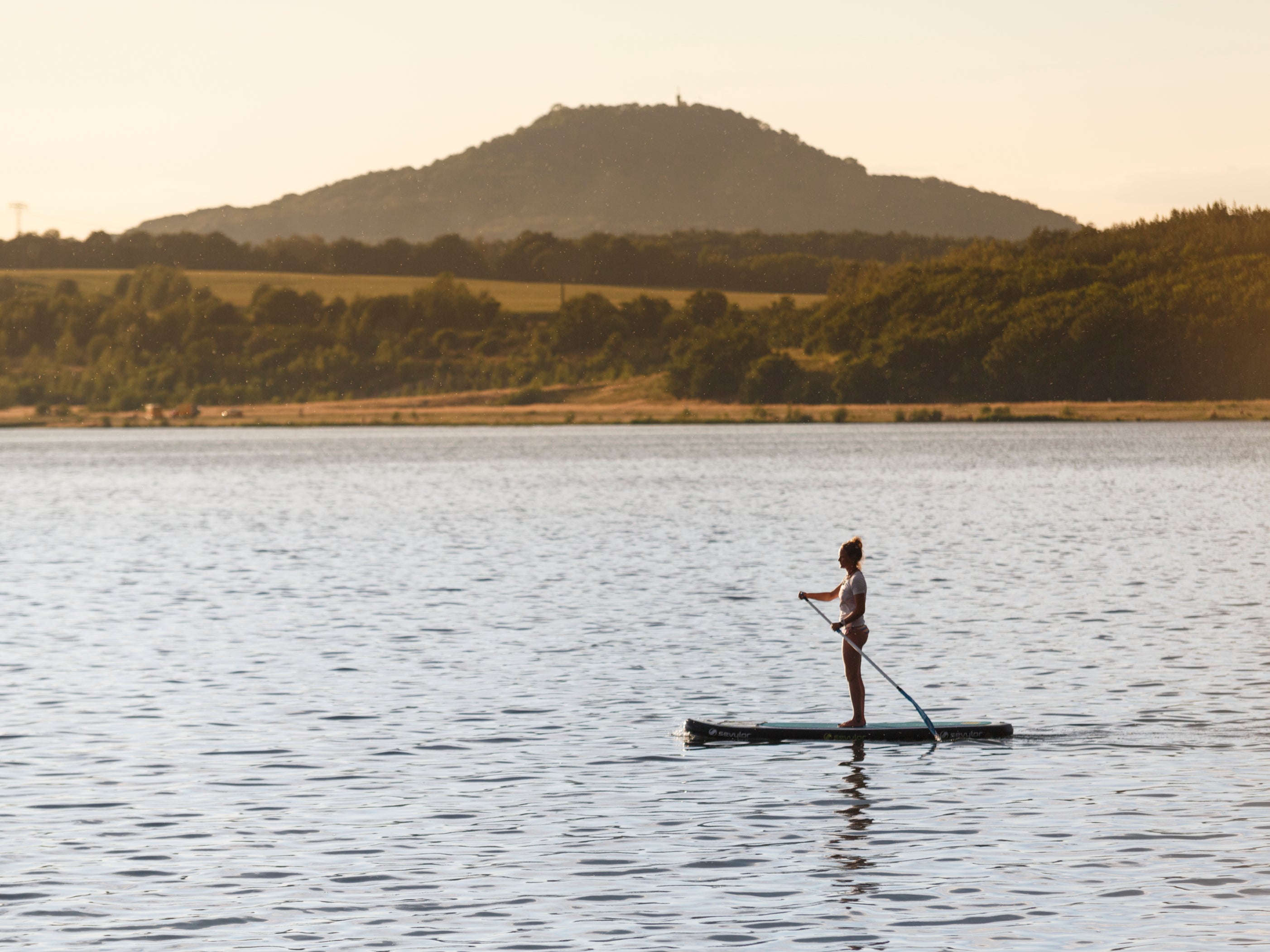 A paddle boarder on the tranquil, man-made Berzdorfer lake