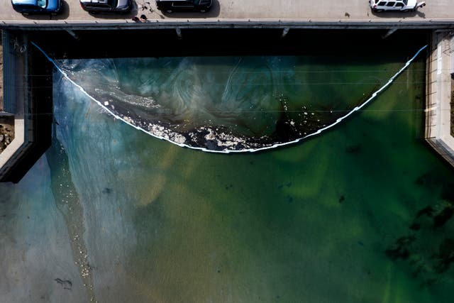 <p>An aerial photo taken on Monday shows floating barriers known as booms set up to try to stop further incursion of the leaked oil into the Wetlands Talbert Marsh after an oil spill at Huntington Beach</p>