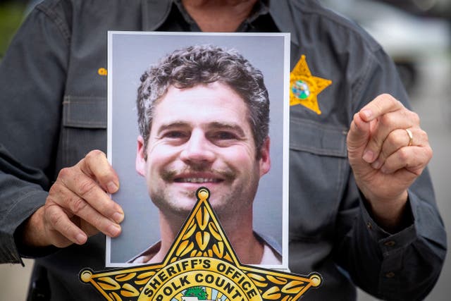 <p>Polk County Sheriff Grady Judd holds up a photo of  Shaun Runyon, who is accused of killing his co-workers</p>