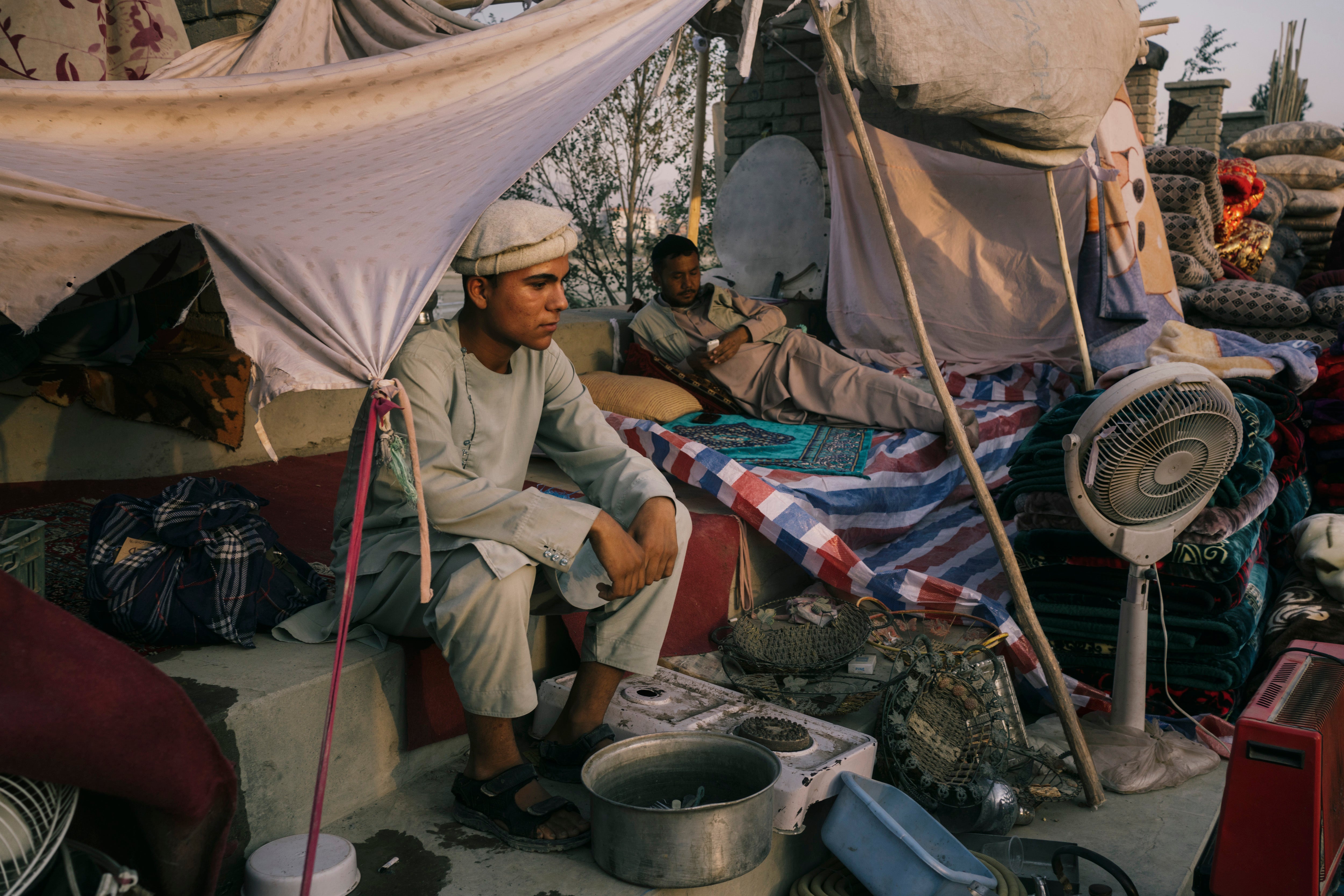 A family waits for buyers in a sprawling market that has appeared near Ghazi Stadium in Kabul