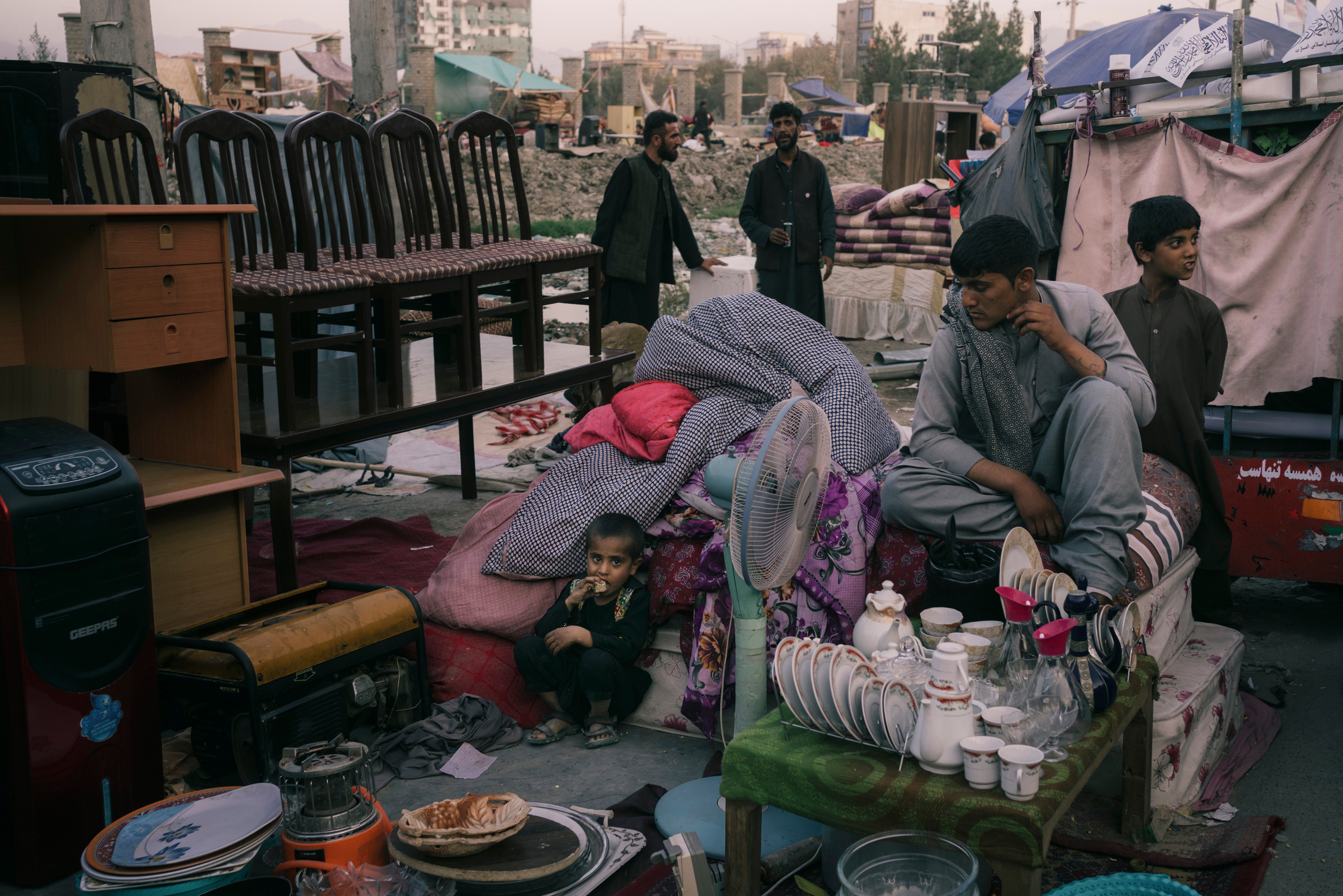 A family waits for buyers in a sprawling market near Ghazi Stadium