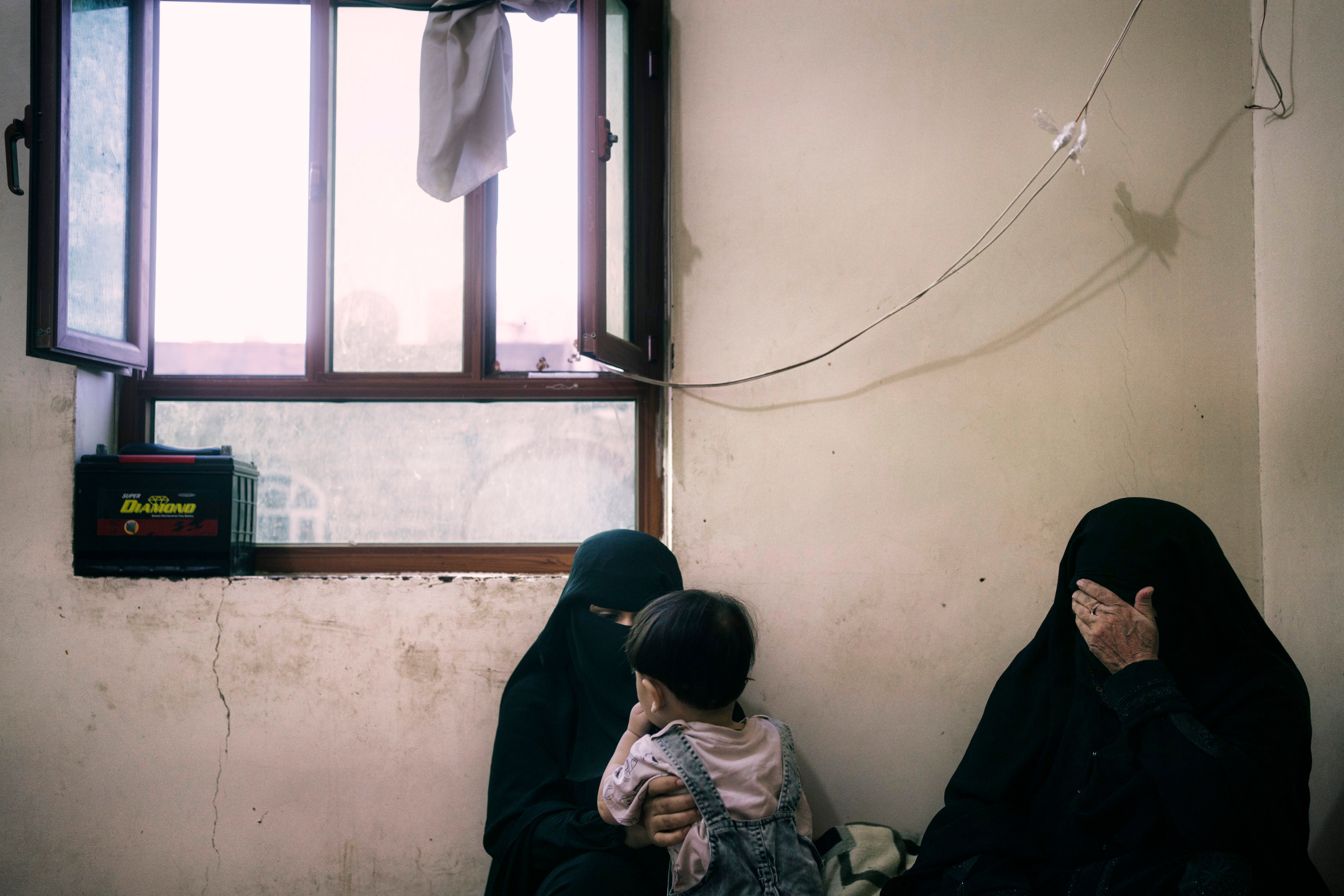 Jamila Saleh Ali Duma, whose husband and daughter died in a Houthi missile attack, with her son and mother-in-law