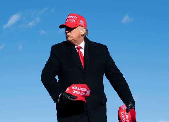 <p>US President Donald Trump throws hats to supporters during a Make America Great Again rally in November 2020 </p>