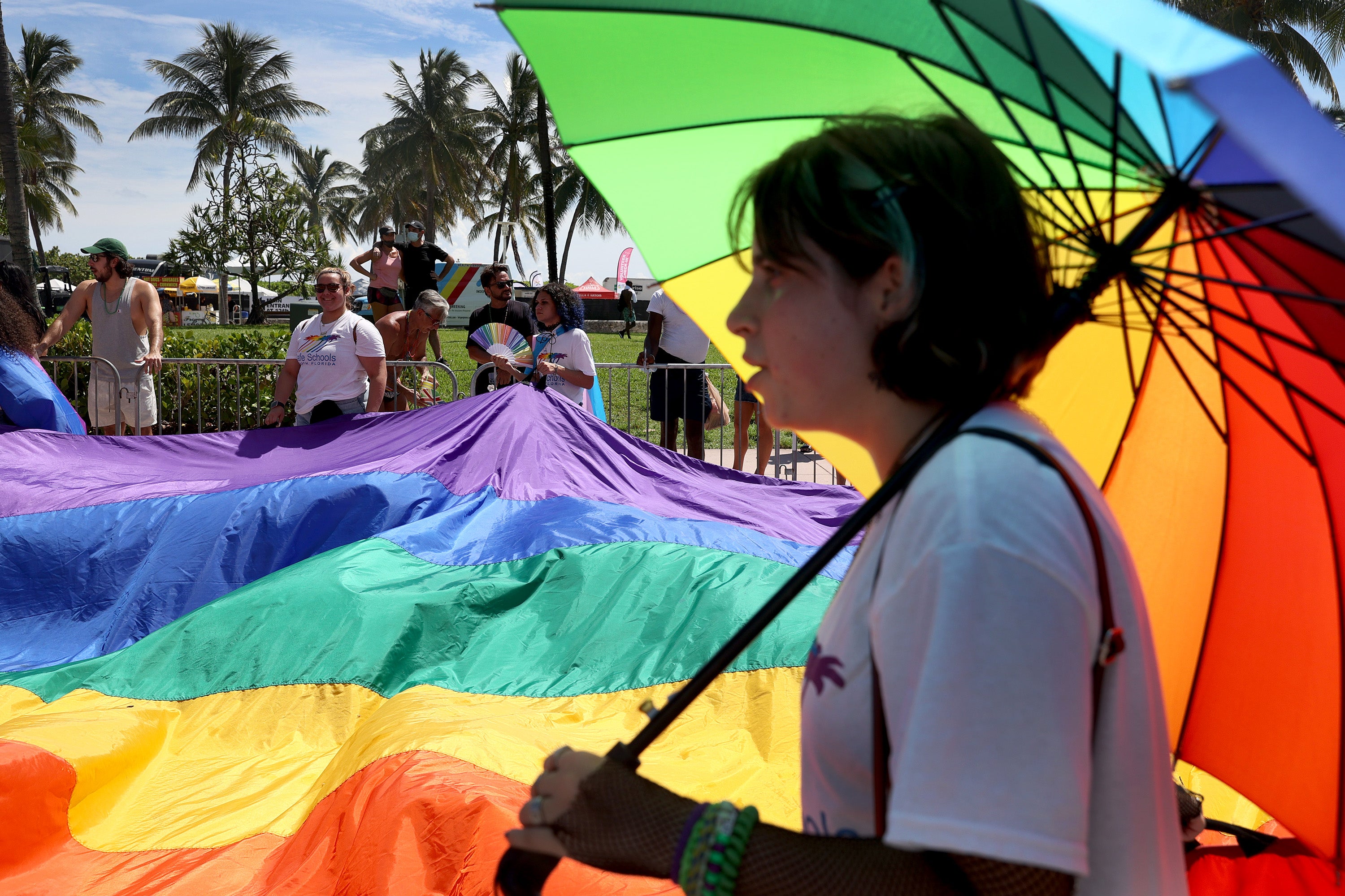 People carry the rainbow flag as they participate in the Miami Beach Pride Parade along Ocean Drive on 19 September 2021 in Miami Beach, Florida
