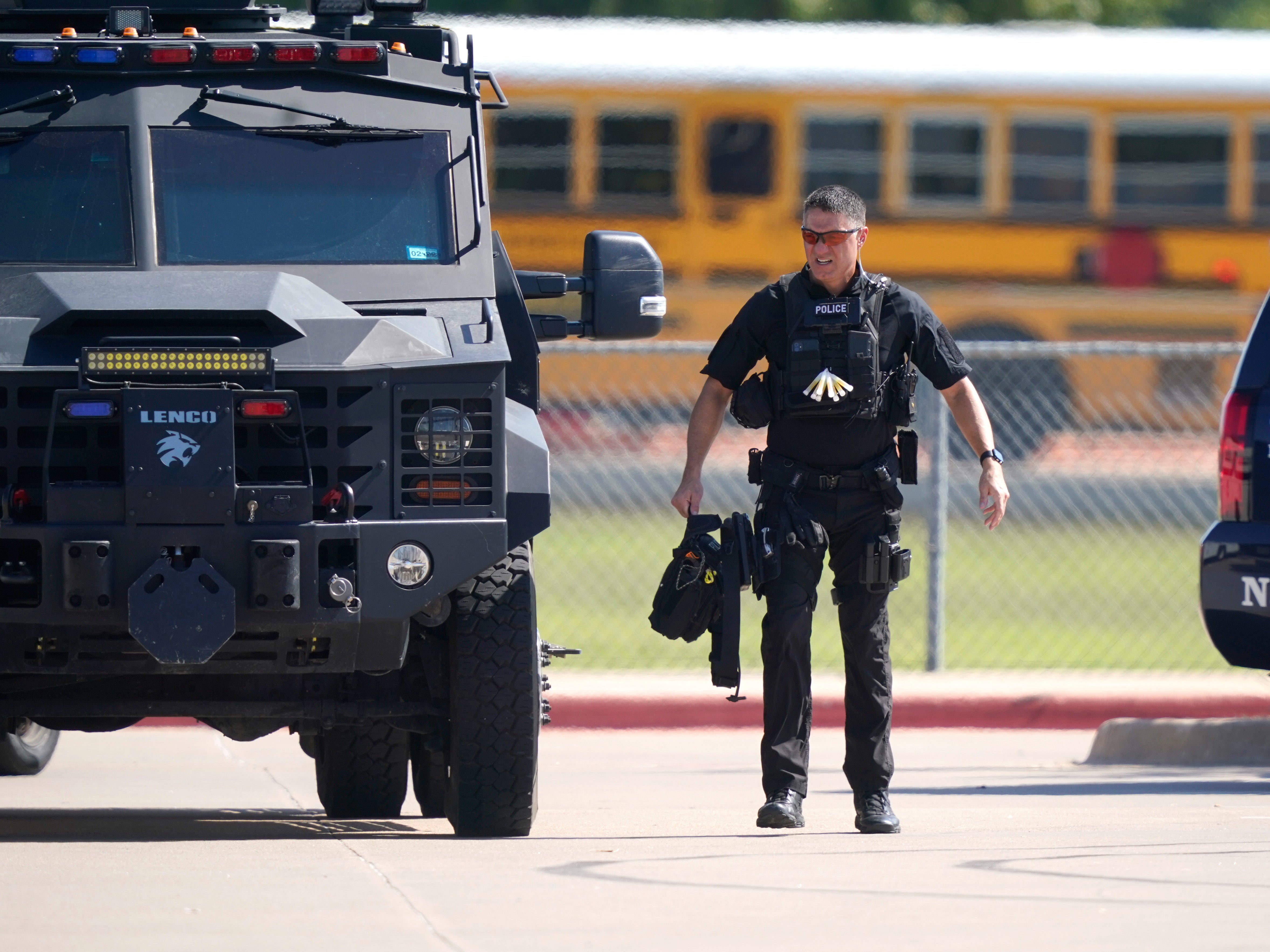 A law enforcement officer walks in the parking lot of Timberview High School after a shooting inside the school in south Arlington, Texas, Wednesday, Oct. 6, 2021