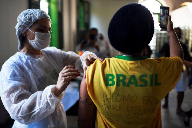 <p>File: A health worker administers a Covid vaccine dose to a resident as he takes a selfie, during mass vaccination at the Ilha Grande island, one of the most famous tourist spots in Rio de Janeiro state, Brazil</p>