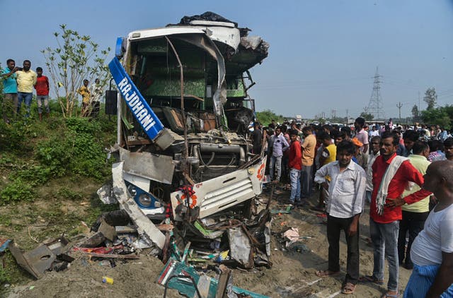 <p>People stand near the wreckage of a bus that collided with a truck in Barabanki district in Uttar Pradesh state, India</p>