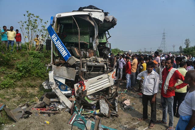 <p>People stand near the wreckage of a bus that collided with a truck in Barabanki district in Uttar Pradesh state, India</p>