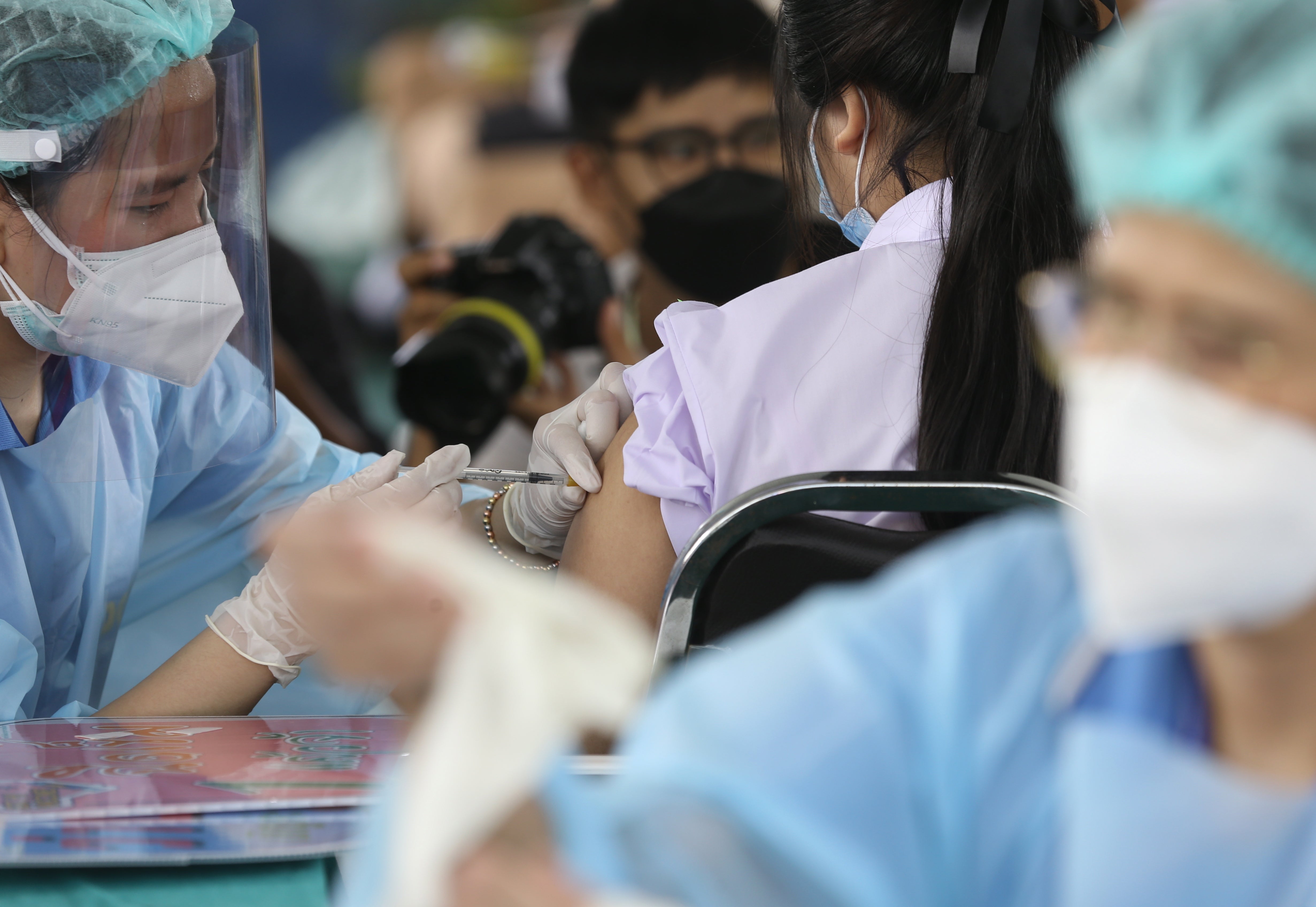 A health official administers a dose of the Pfizer vaccine to a student during the initiation of a Covid-19 vaccination drive for students at Pibool Uppatham school, in Bangkok, Thailand on 4 October 2021